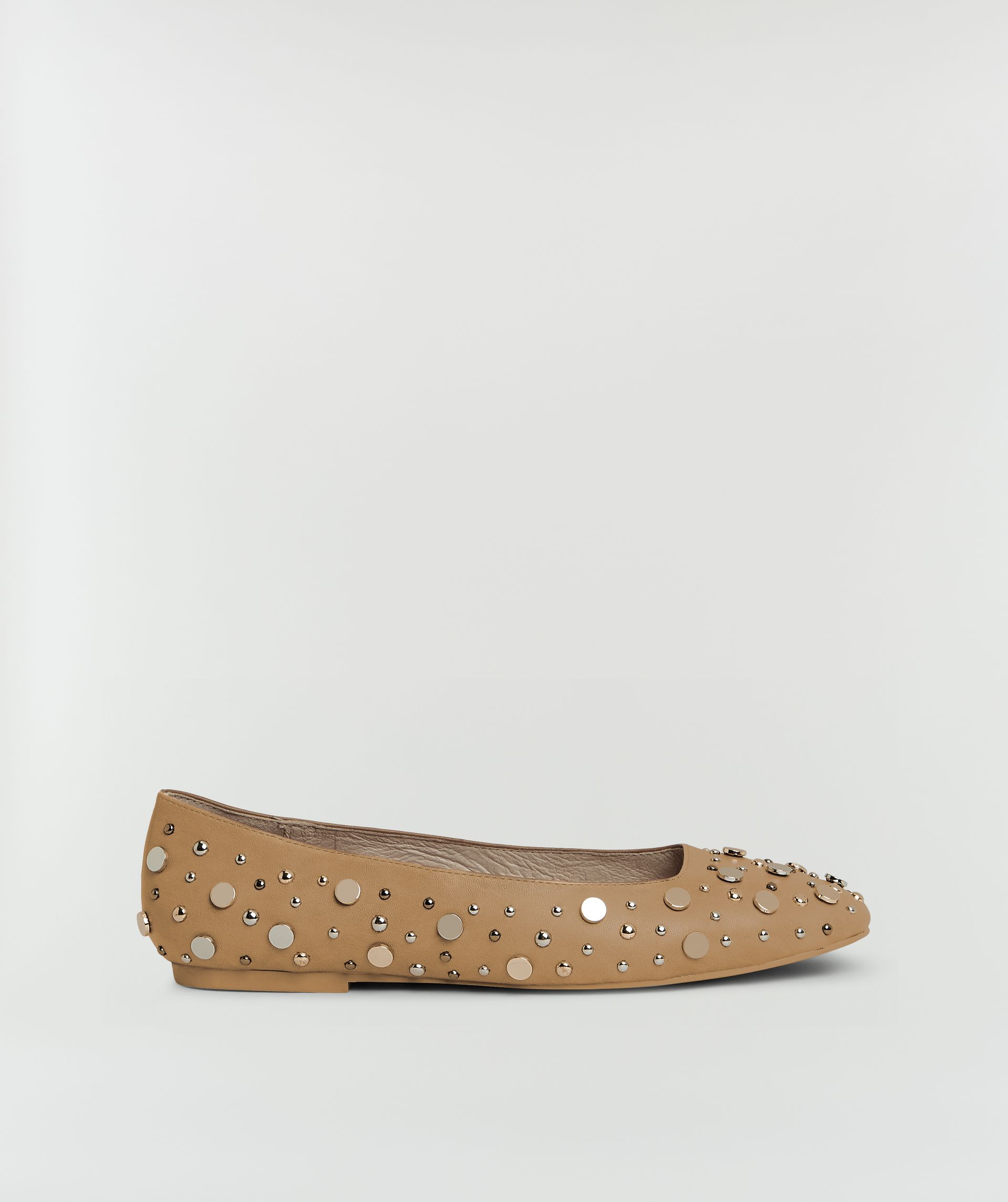 Zijaanzicht van beige ballerina's  met studs zonder model, weergegeven op een lichtgrijze achtergrond.