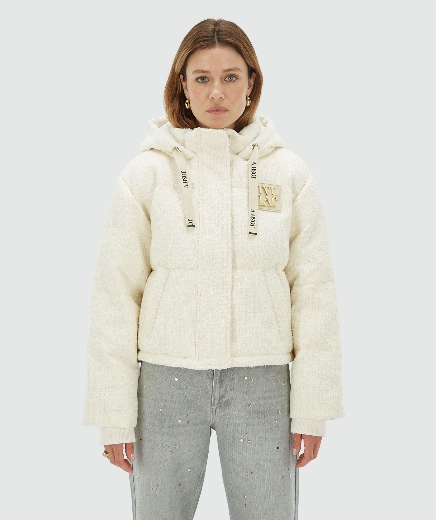 Model draagt een Creme White gewatteerde jas met capuchon en gouden JOSH V monogram logo op de borst - Josh V