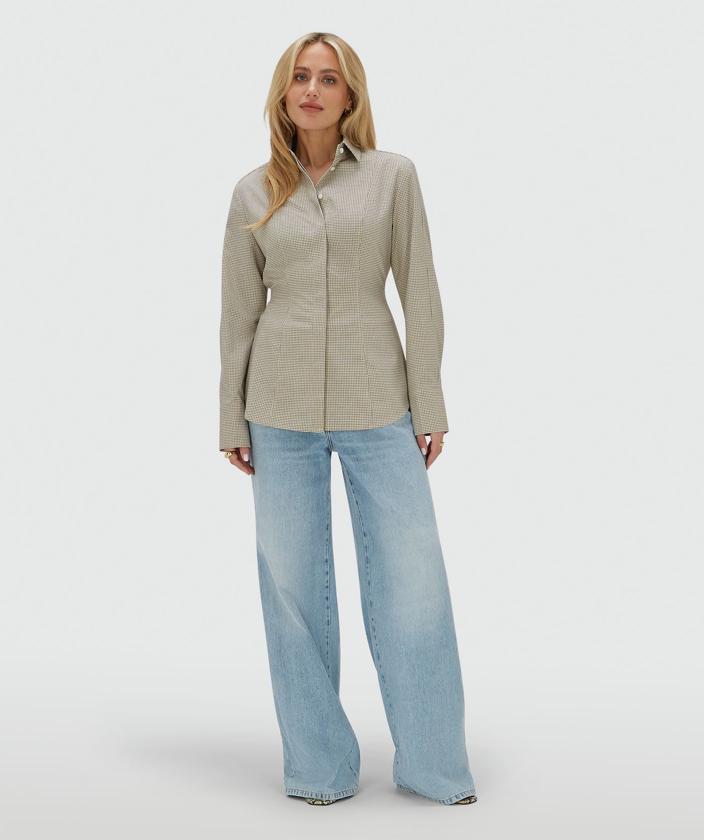 Model draagt een fitted blouse met schoudervullingenn in het Stone Check-patroon
