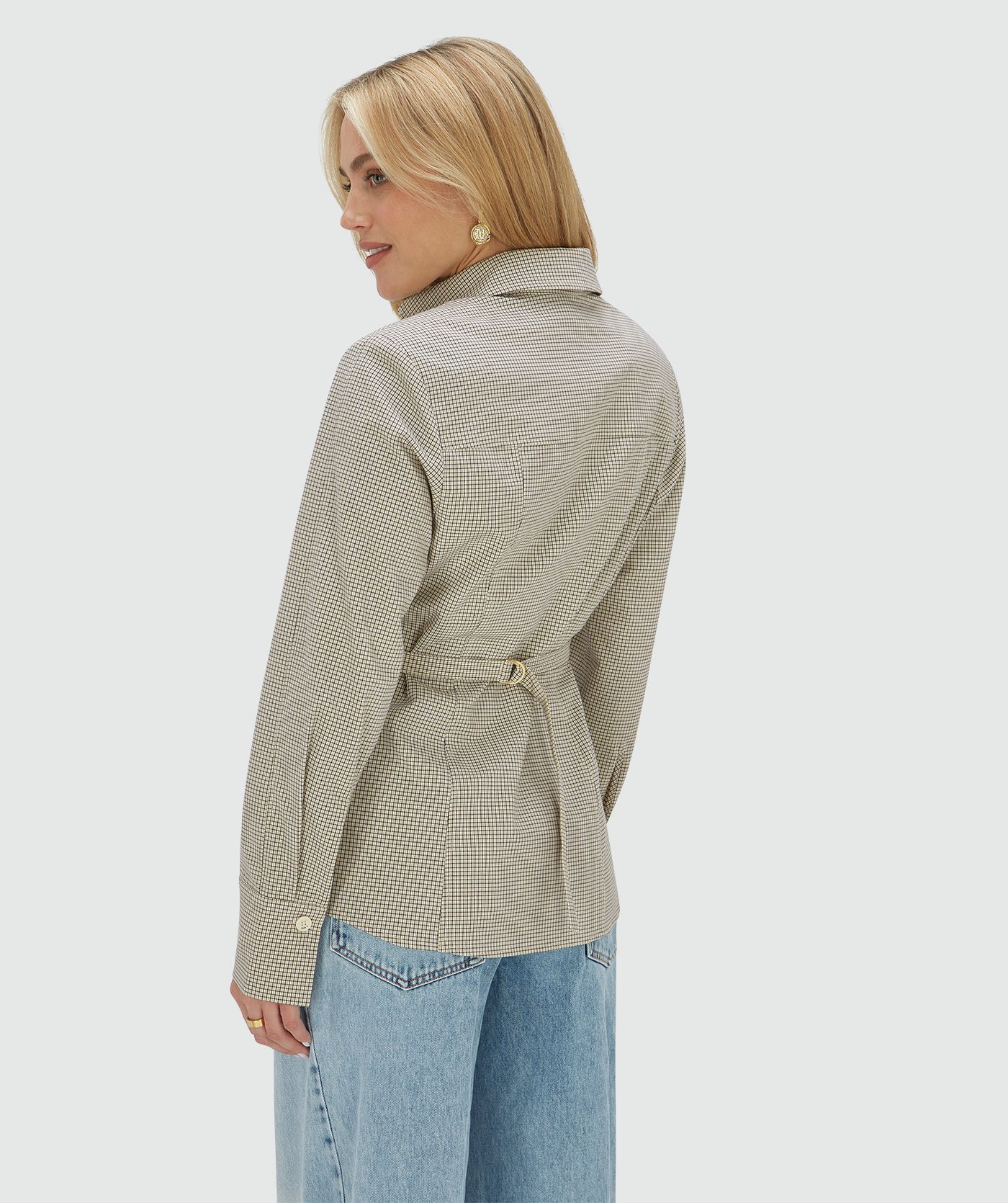 Achteraanzicht van een model in een fitted blouse met schoudervullingen in het Stone Check-patroon