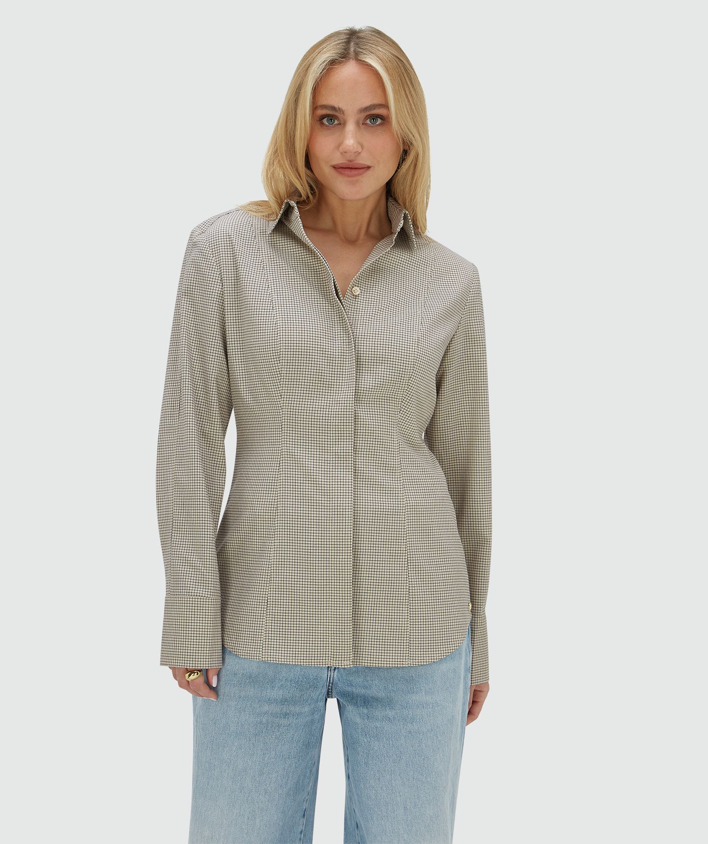 Model draagt een fitted blouse met schoudervullingen in het Stone Check-patroon