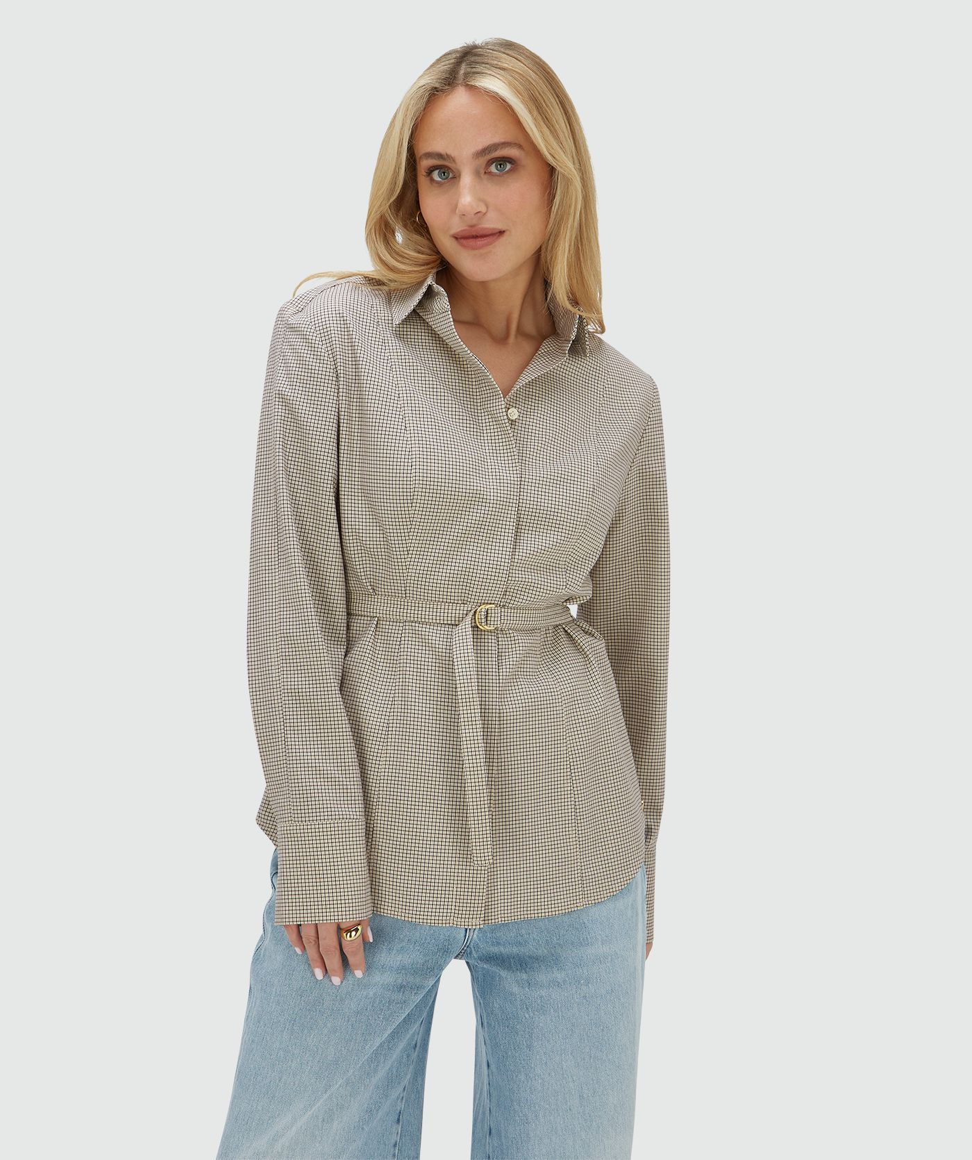 Model draagt een fitted blouse met schoudervullingen in het Stone Check-patroon