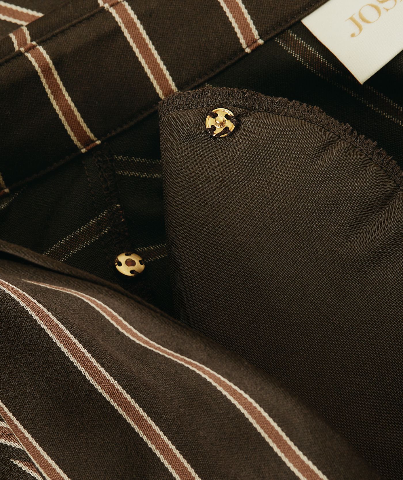 Close-up van een regular fit blouse met strepen waar de schoudervulling wordt weergegeven