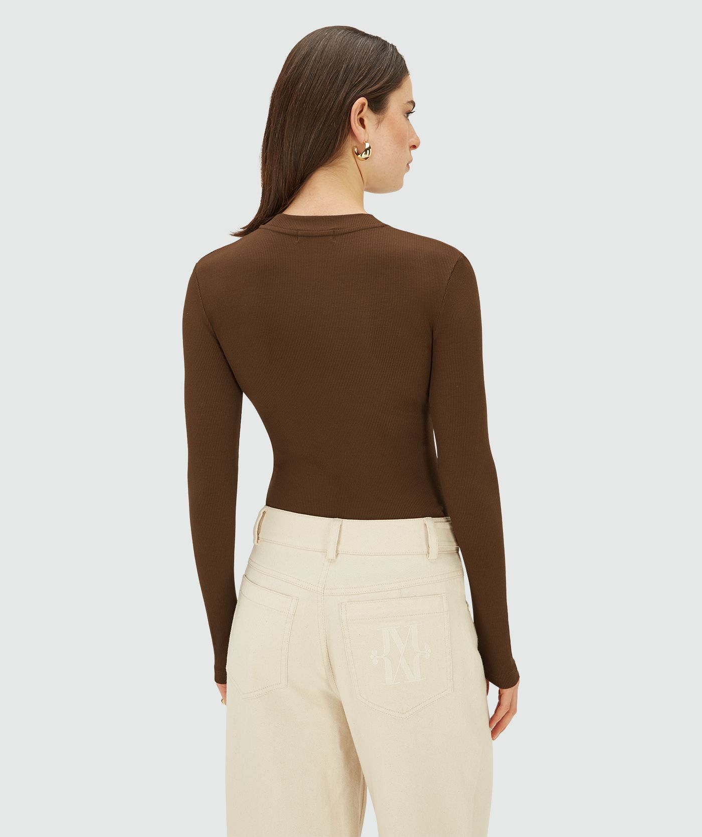 Achteraanzicht van een model in een Brown aansluitende longsleeve met ronde hals en ribstructuur.