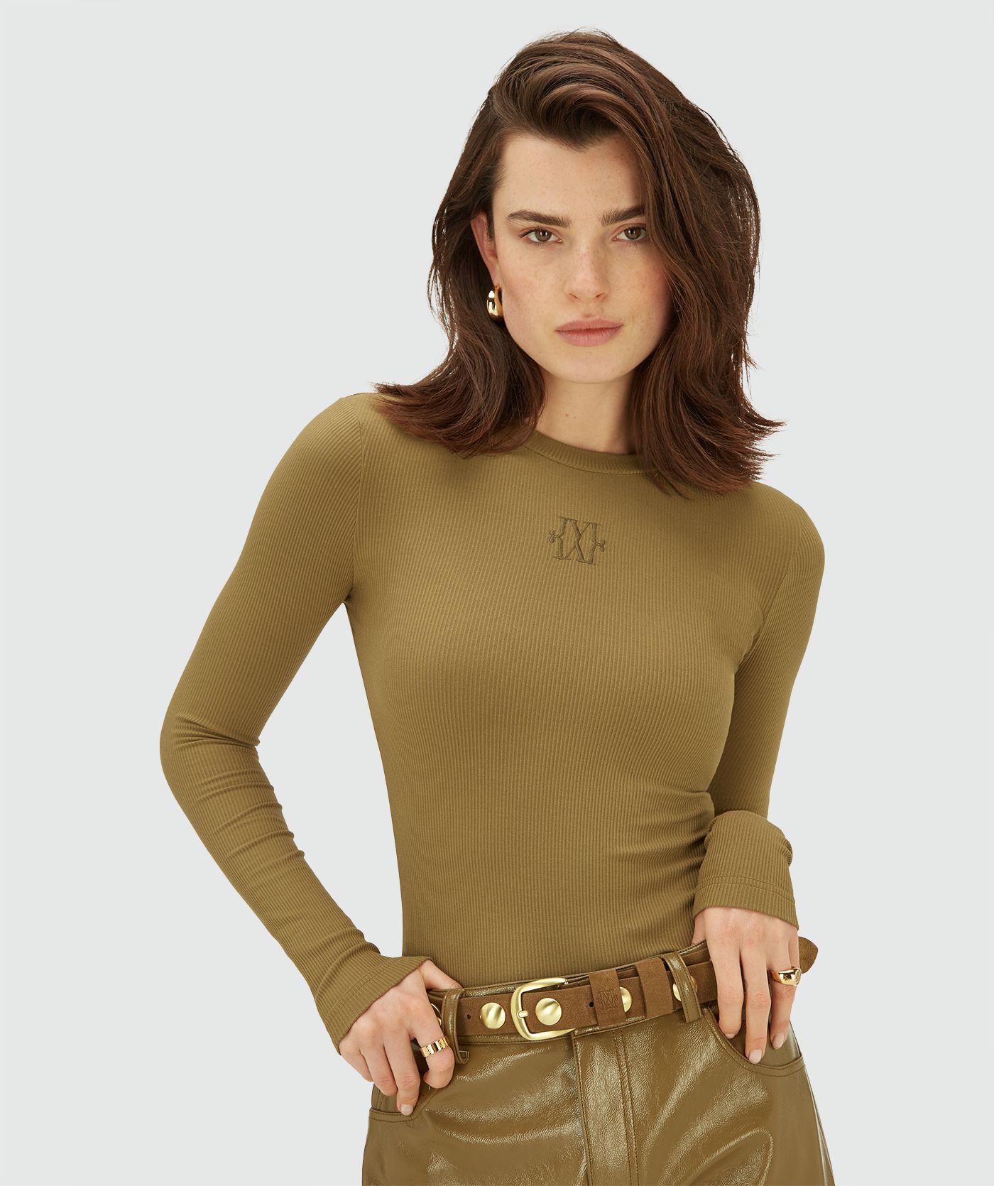 Model draagt een aansluitende Olive Green longsleeve met ronde hals en ribstructuur