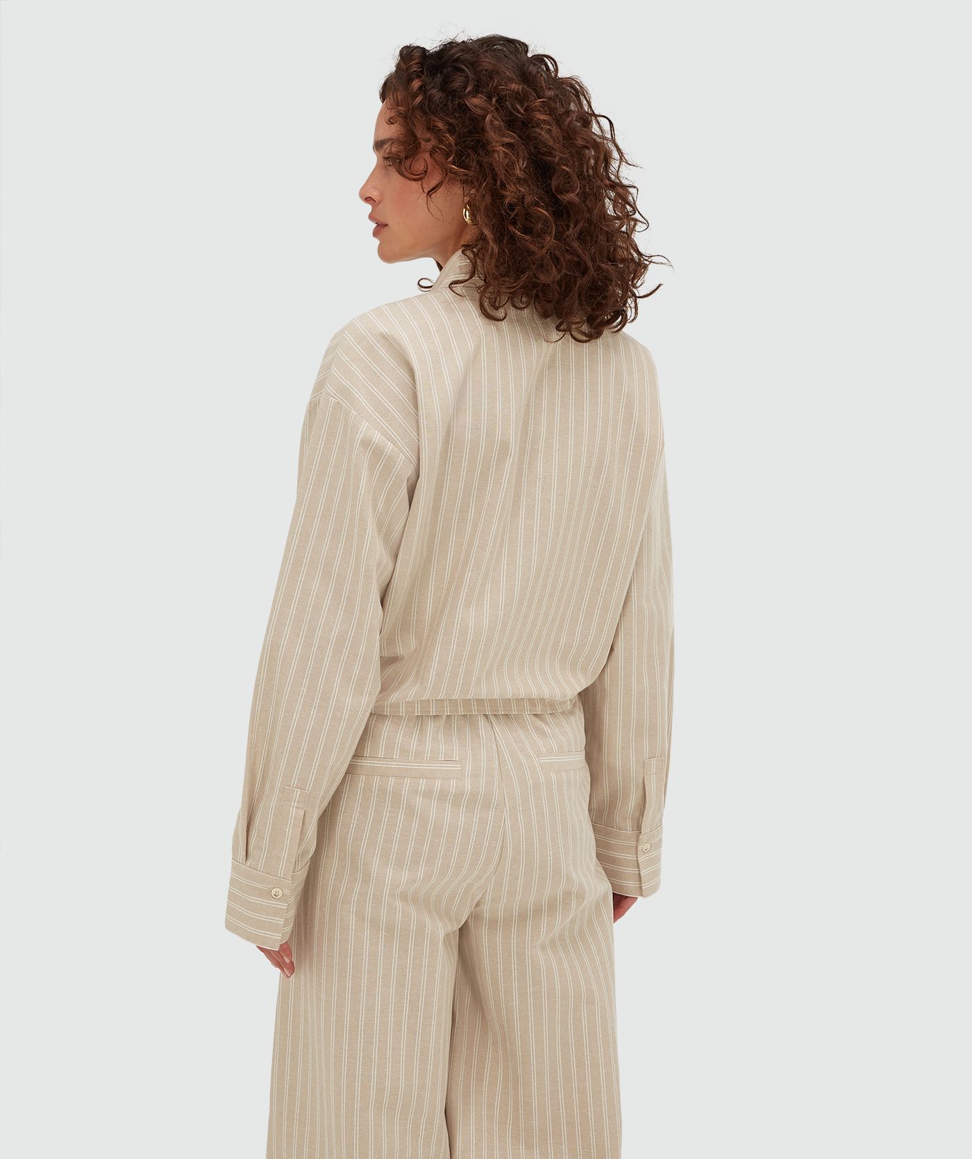 Achterzijde van een model in een relaxed cropped blouse met strepen in de kleur Stone Stripe
