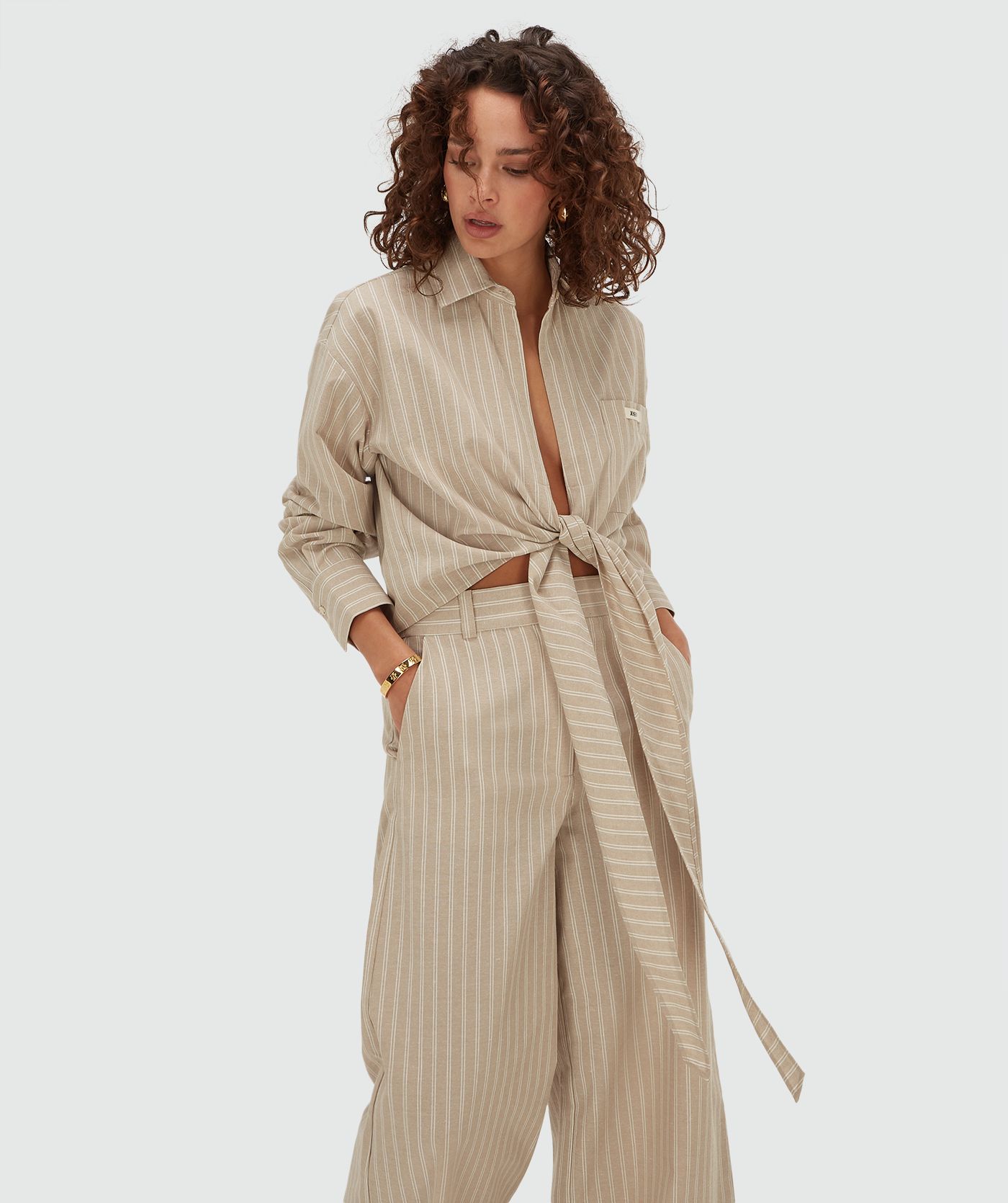 Model draagt een relaxed cropped blouse met strepen in de kleur Stone Stripe