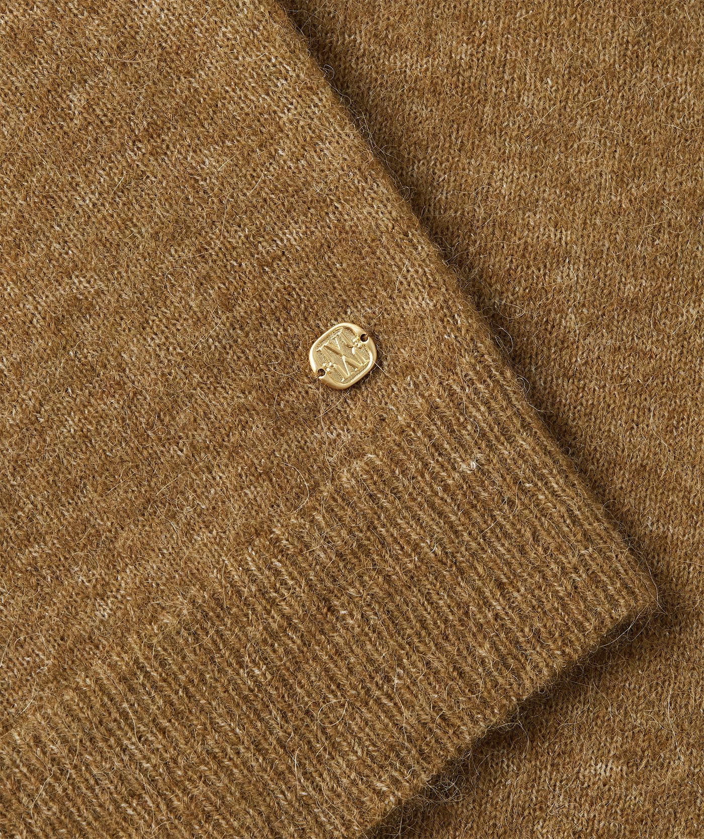 Close-up goudkleurige embleem JOSH V monogram