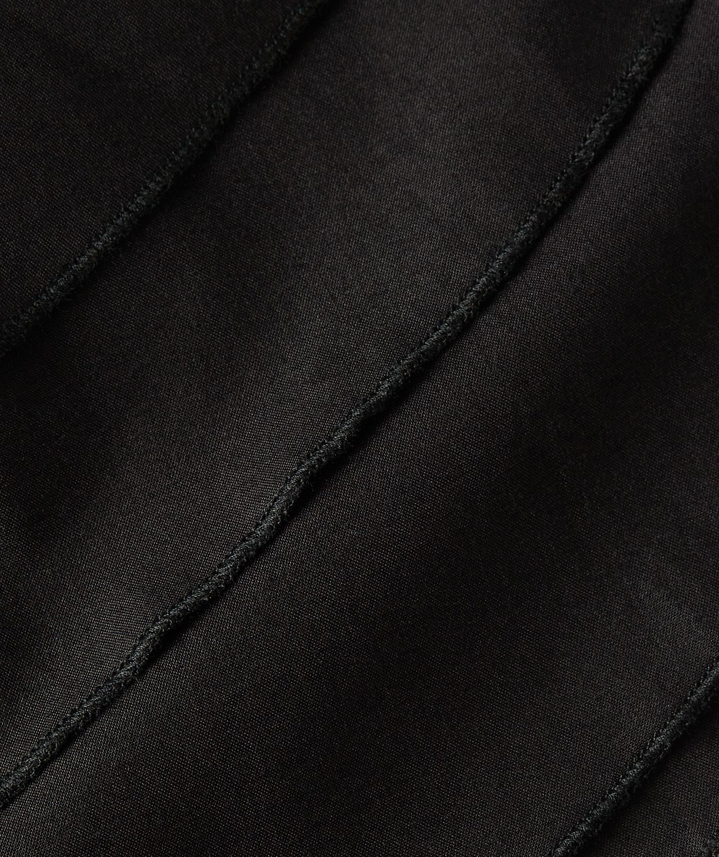 Close-up van ruffle effect van de loose fit jurk in zwart