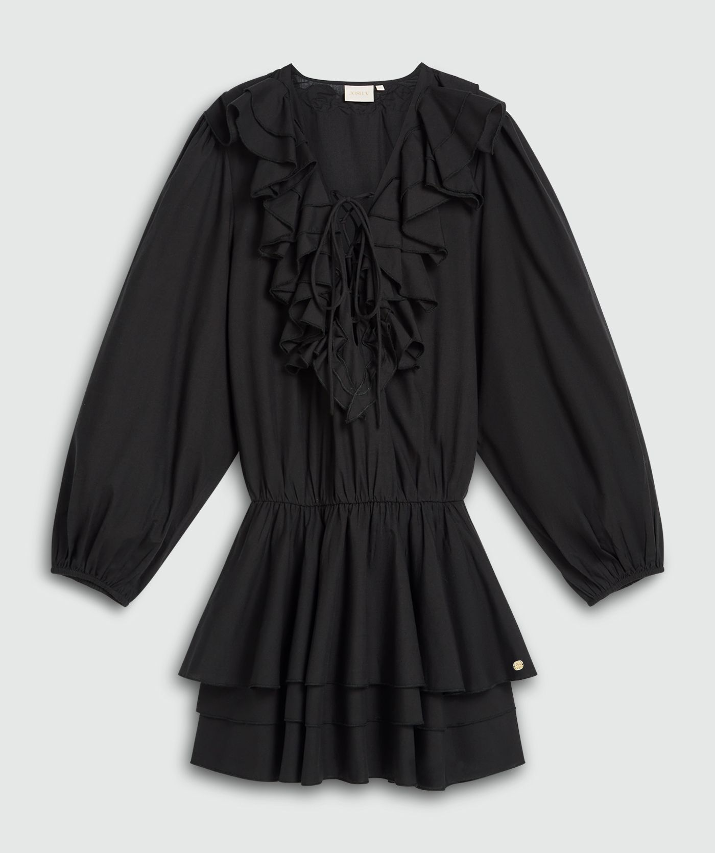 Een loose fit jurk in zwart, met een ruffle-effect bij de halslijn en in de rok, weergegeven tegen een lichtgrijze achtergrond