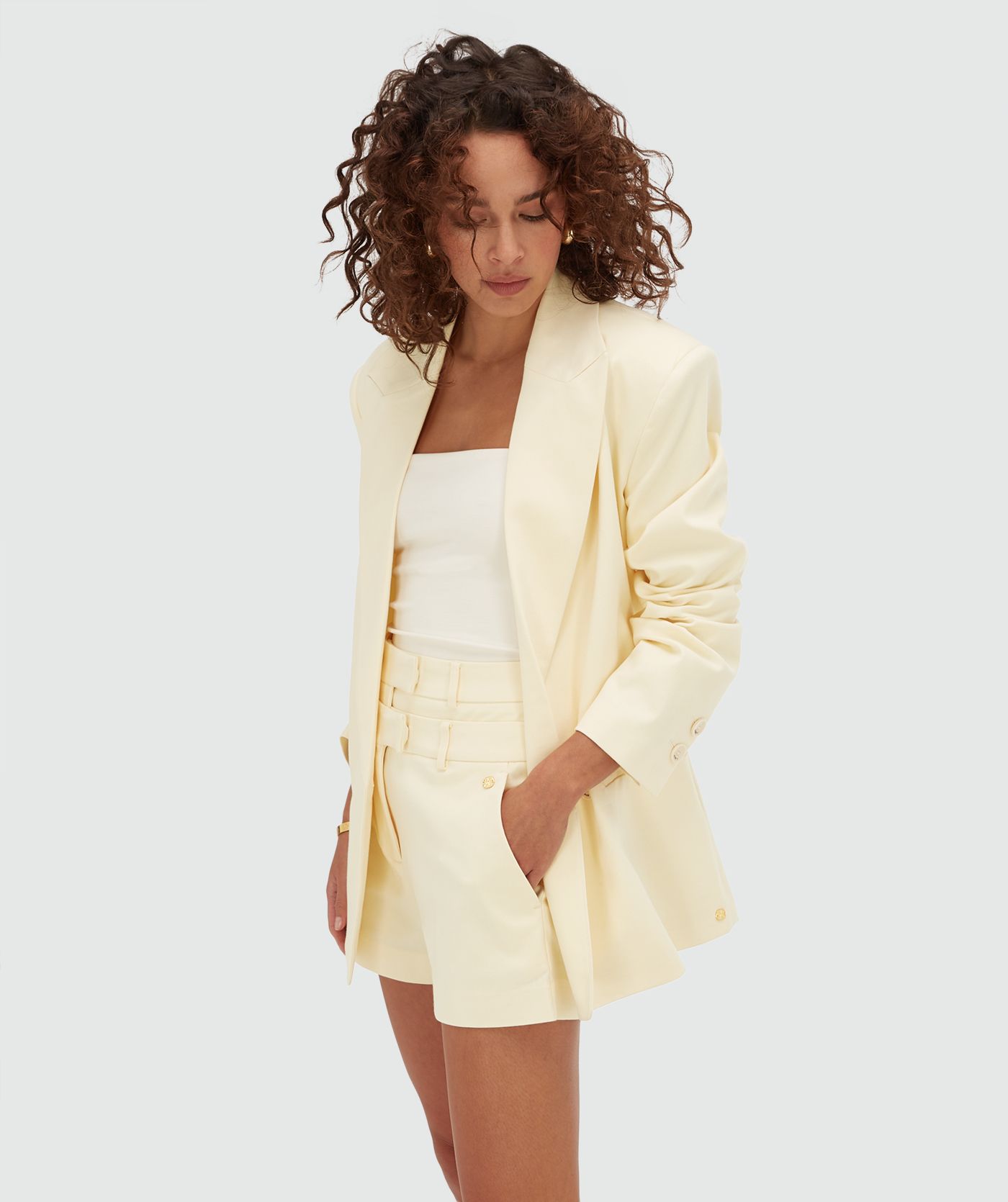 Model draagt een oversized blazer in de kleur Butter Yellow