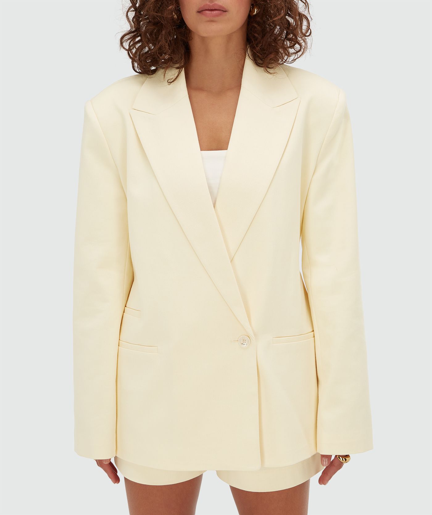 Model draagt een oversized blazer in de kleur Butter Yellow