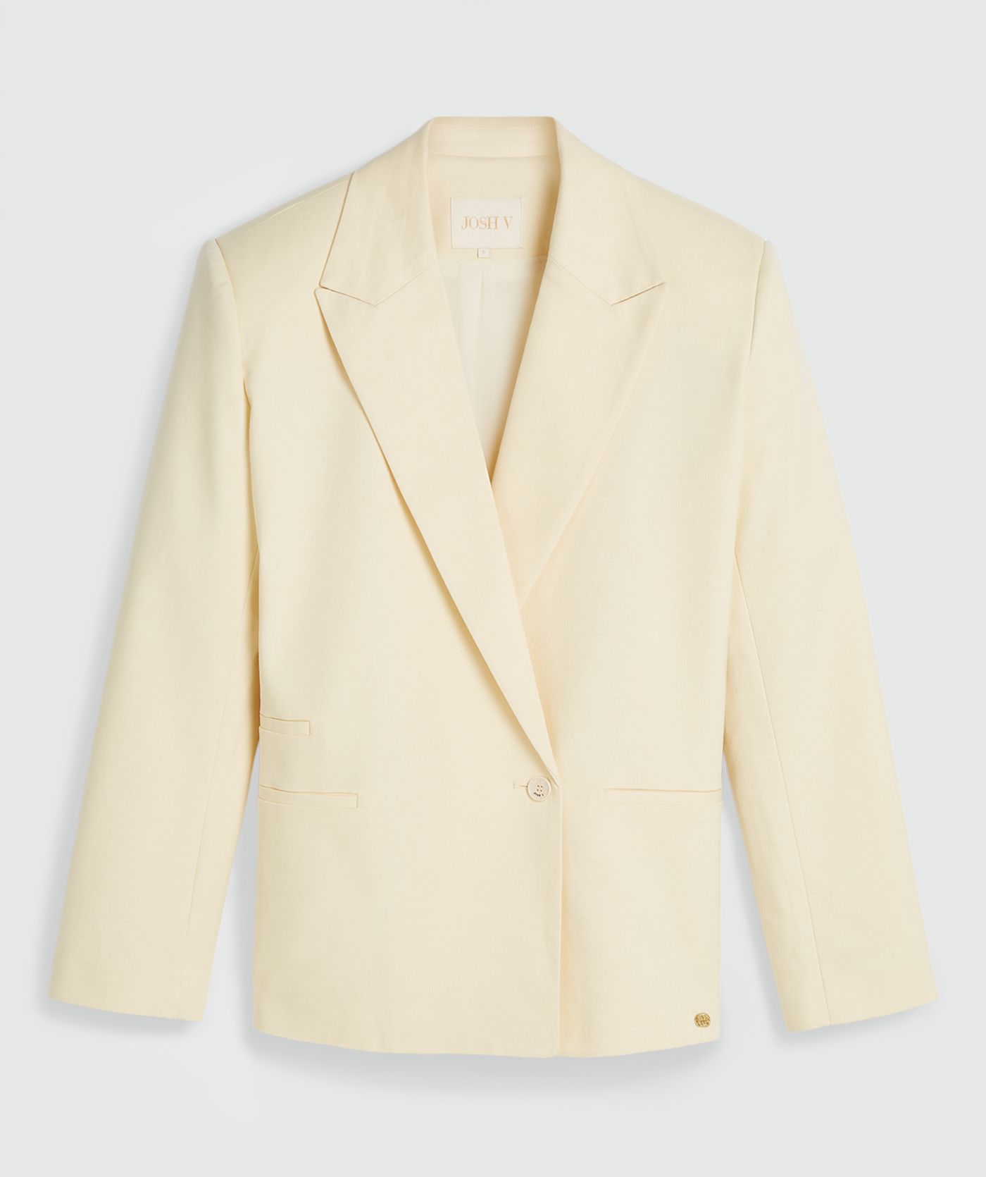Een oversized blazer in de kleur Butter Yellow, zonder model, weergegeven op een lichtgrijze achtergrond