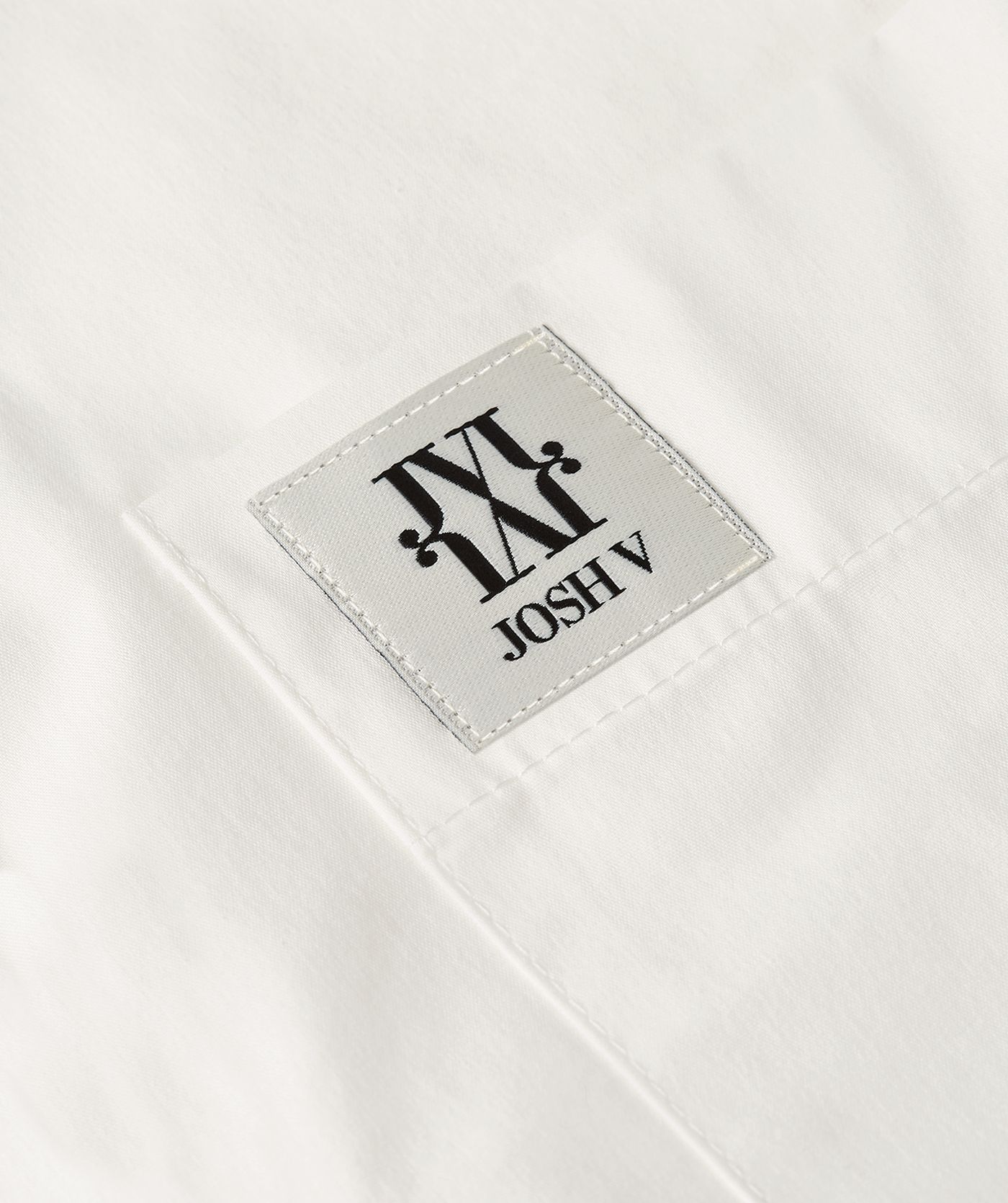Close-up van de borstzak met het JOSH V-logo.