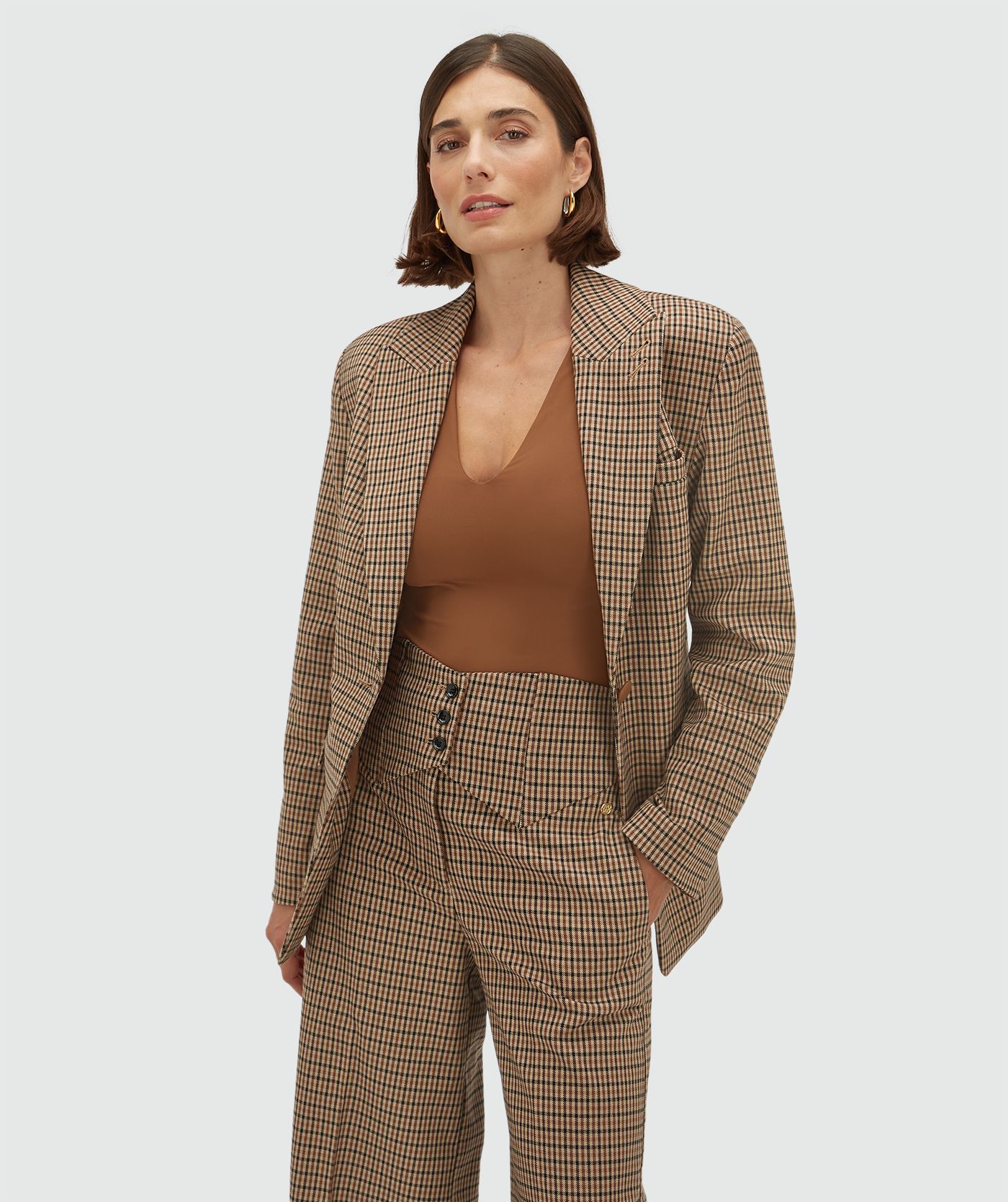 Model draagt een getailleerde blazer met ruitjes 