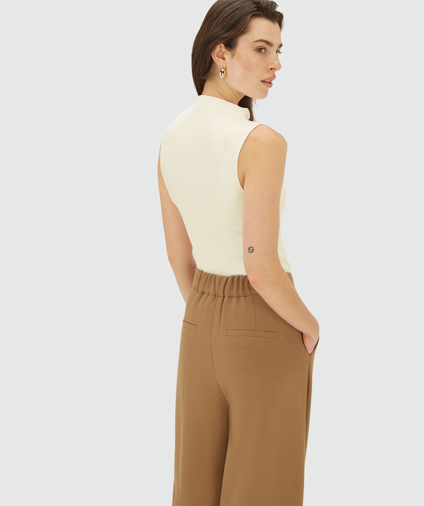 Achteraanzicht van een model in een Creme White sleeveless jersey top 