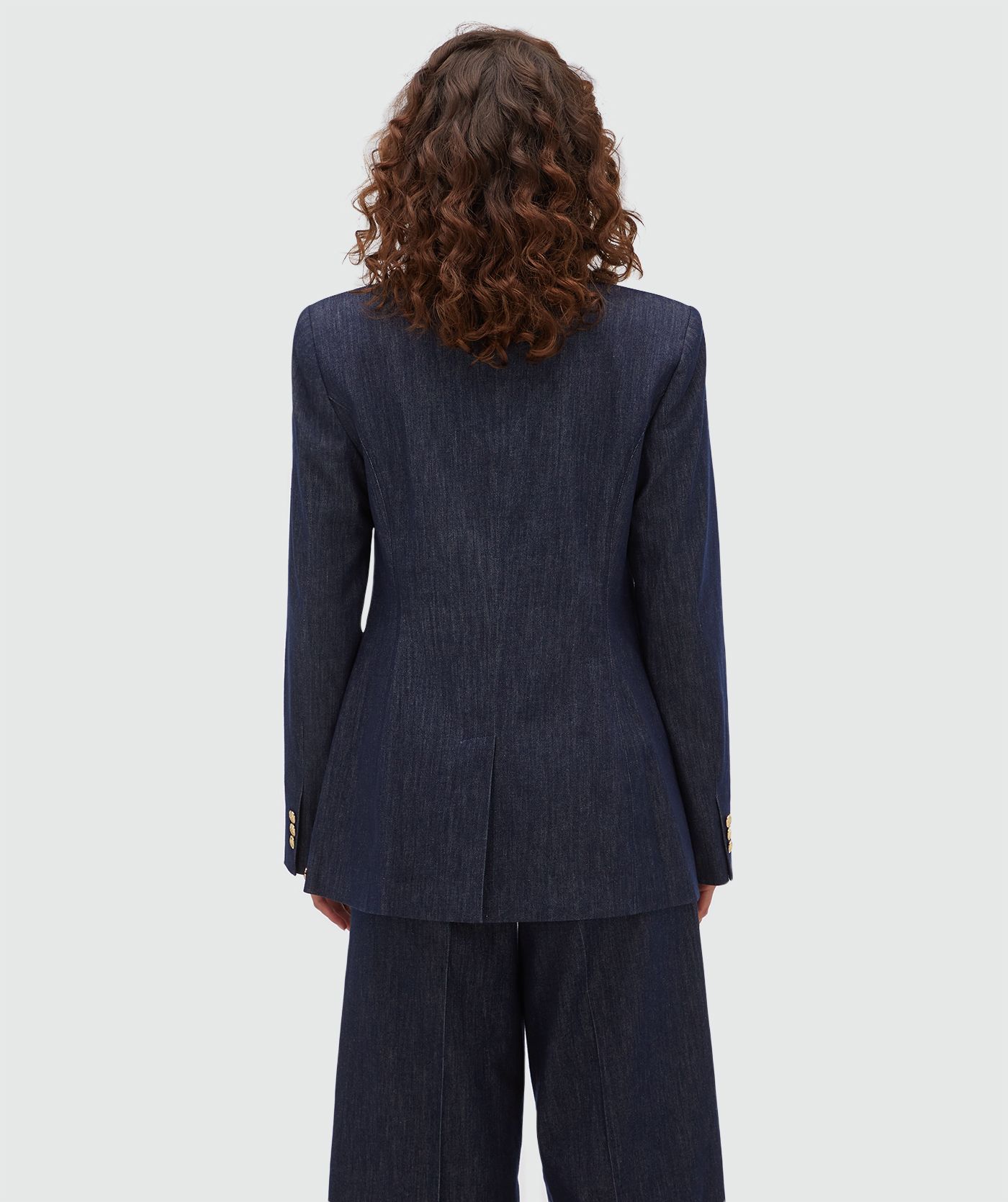 Achteraanzicht van een model in een donkerblauwe blazer.