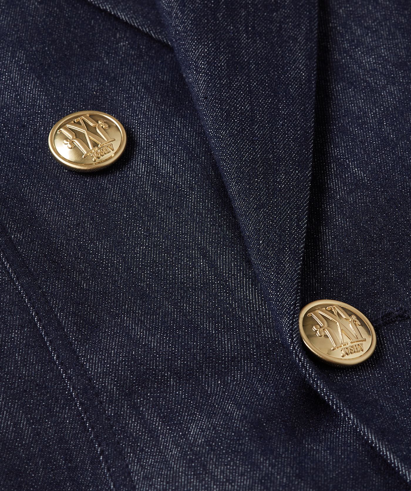 Close-up van de gouden knopen met JOSH V-logo van een donkerblauwe blazer.