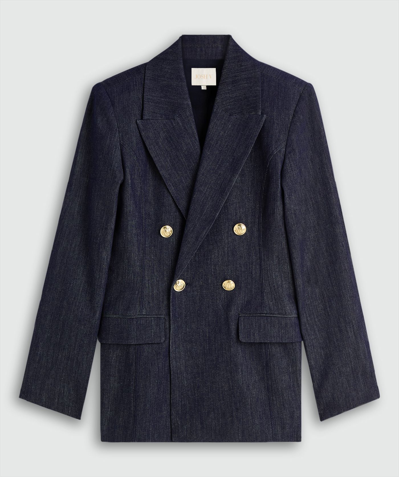 Donkerblauwe blazer met gouden knopen zonder model, weergegeven op een lichtgrijze achtergrond.