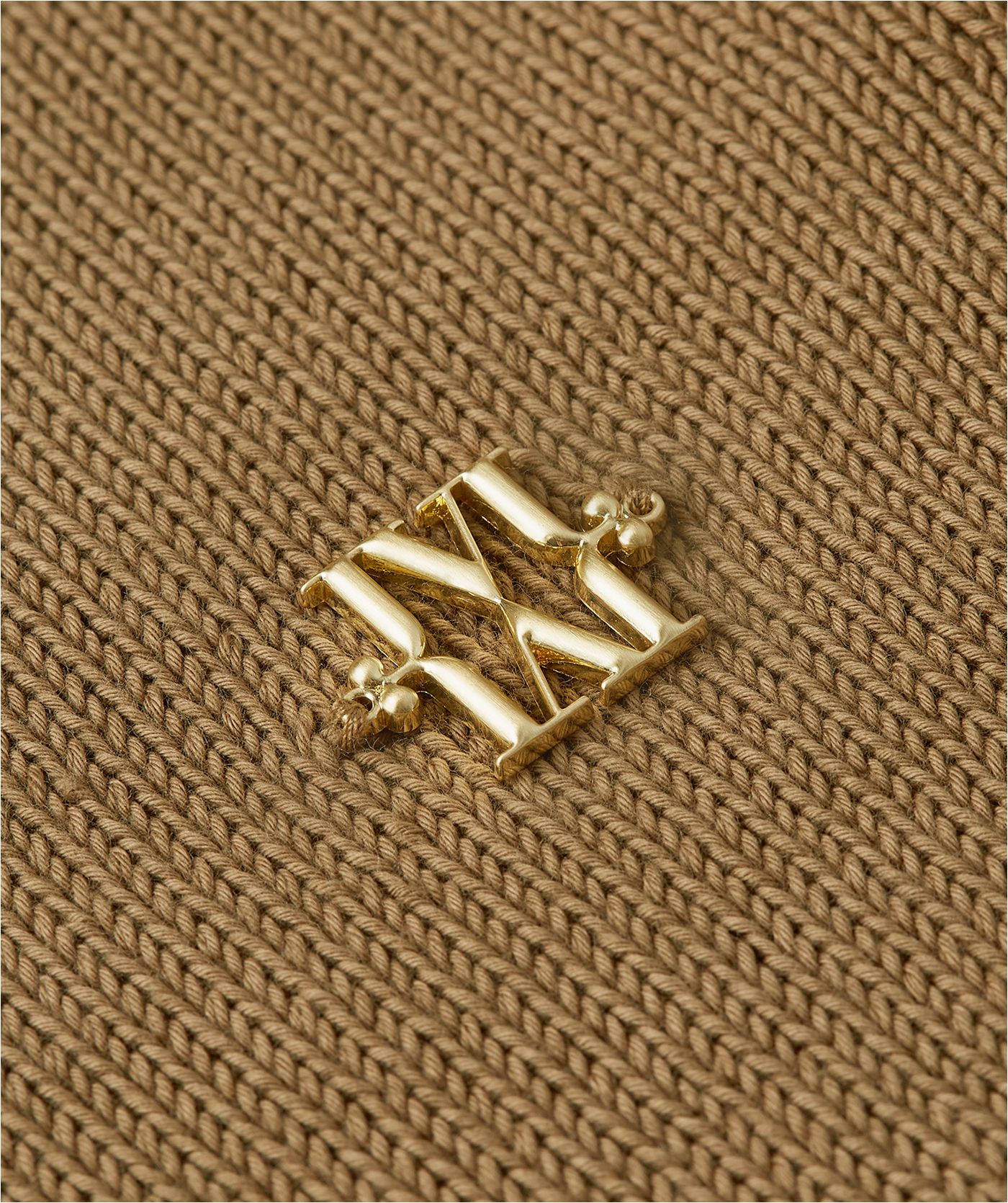 Close-up van gouden JOSH V-logo op de borst.