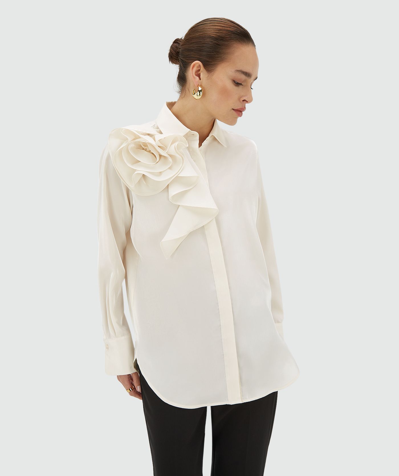 Model draagt een creme white blouse met bloem op de schouder aan de voorzijde - JOSH V