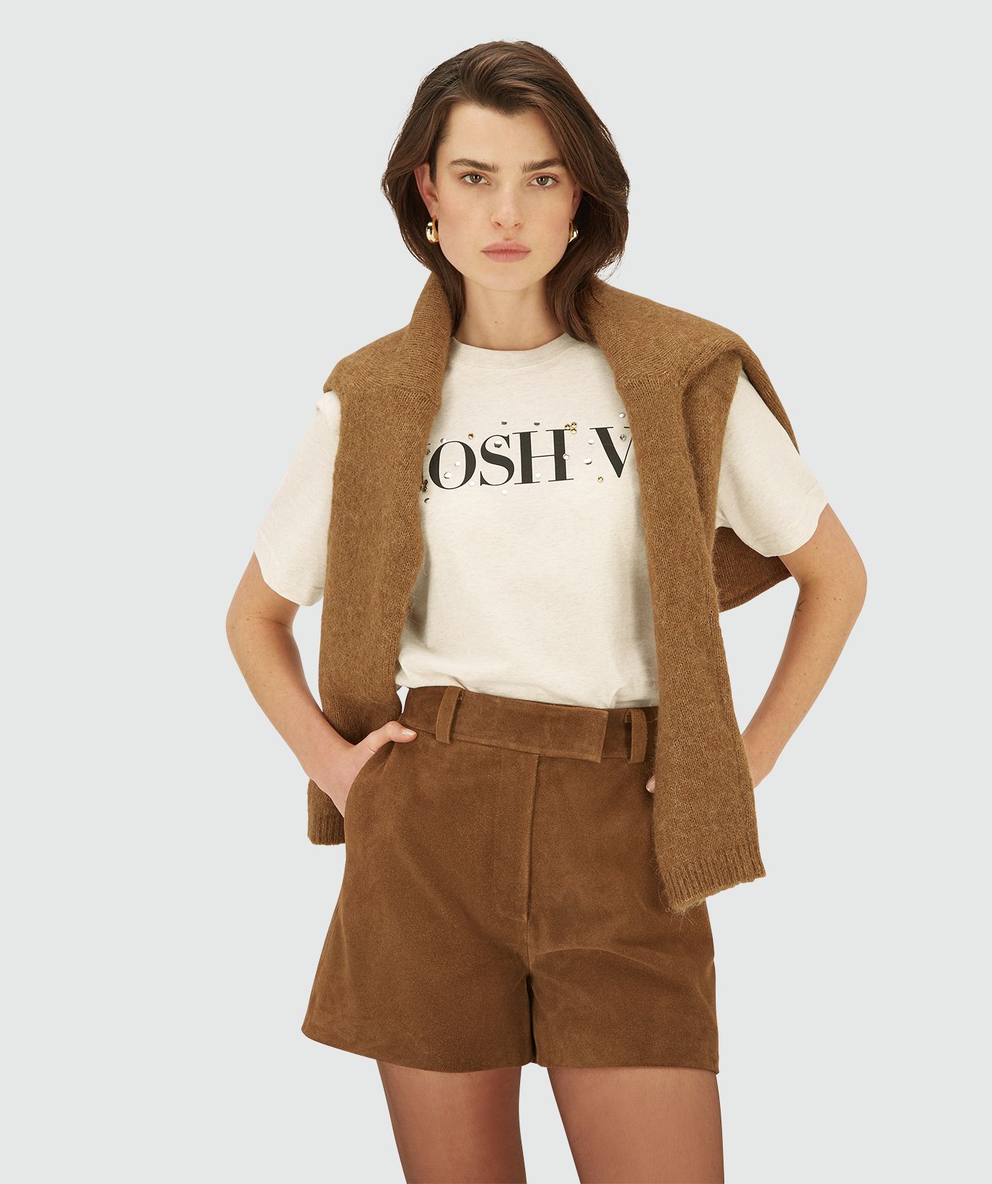 Model draagt een Ecru Melange oversized short sleeve T-shirt met ronde hals. Het T-shirt heeft een JOSH V logo op de borst met strass-steentjes