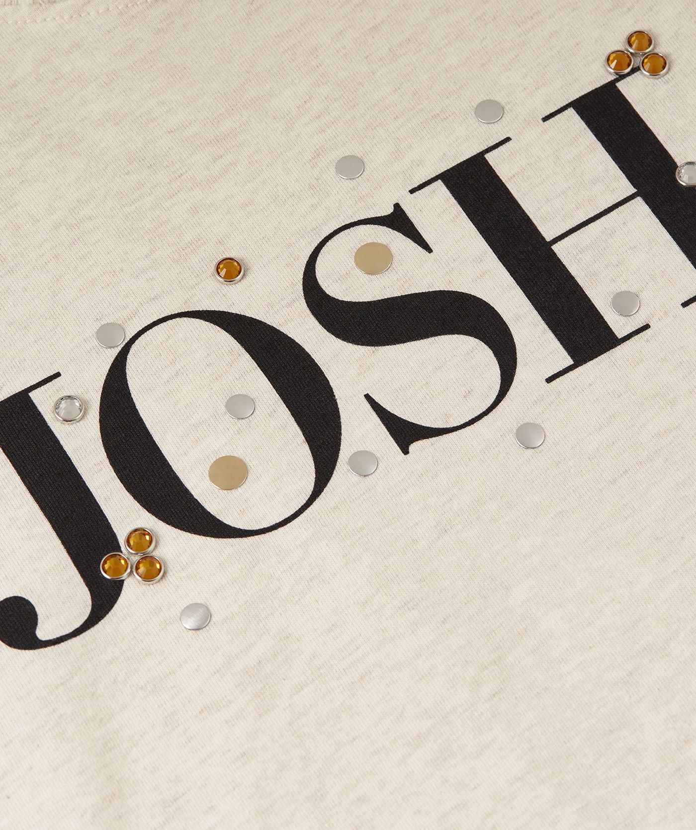 Close-up van het  JOSH V logo op de borst met strass-steentjes