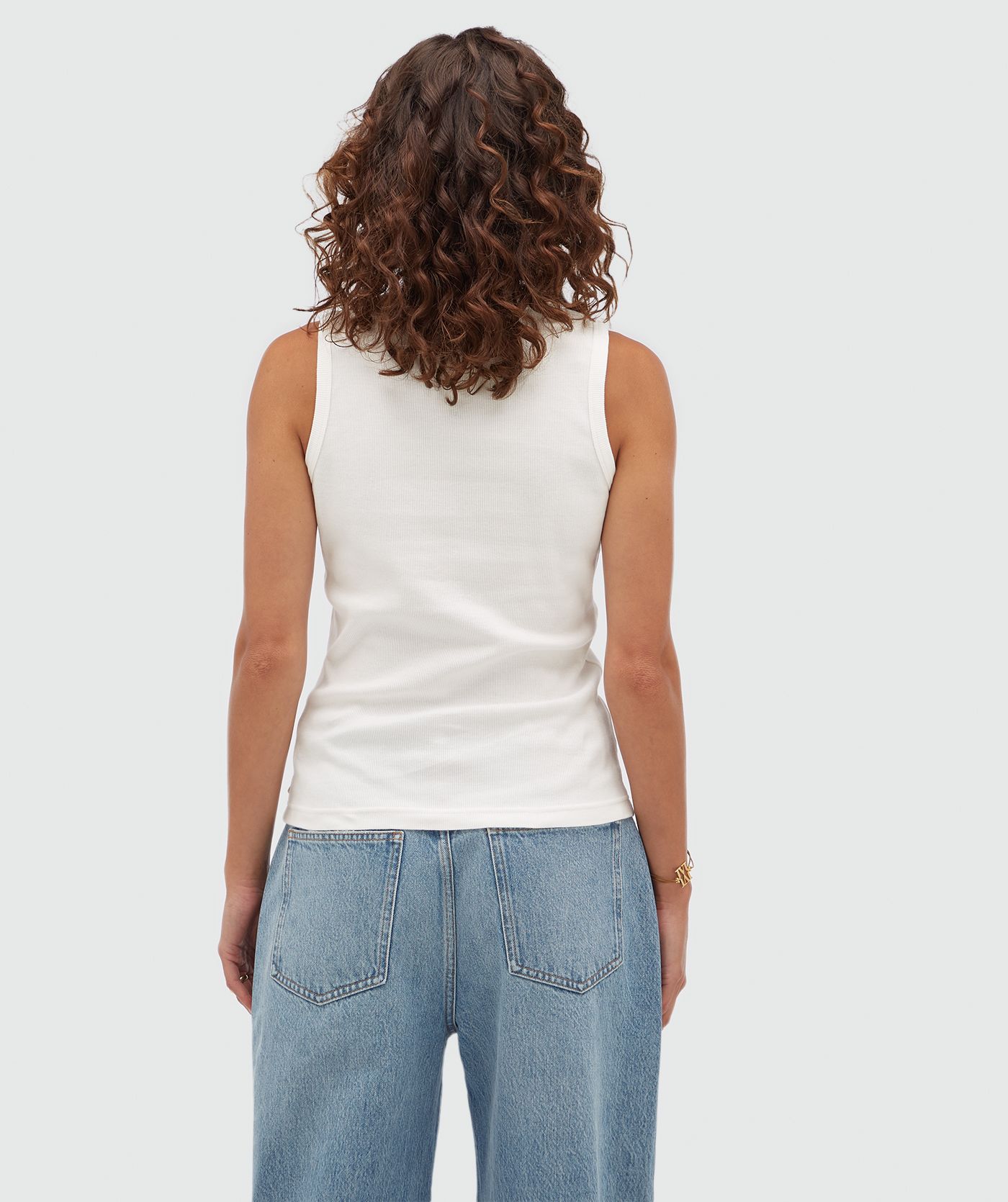 Achteraanzicht van een model in een wit topje zonder mouwen.