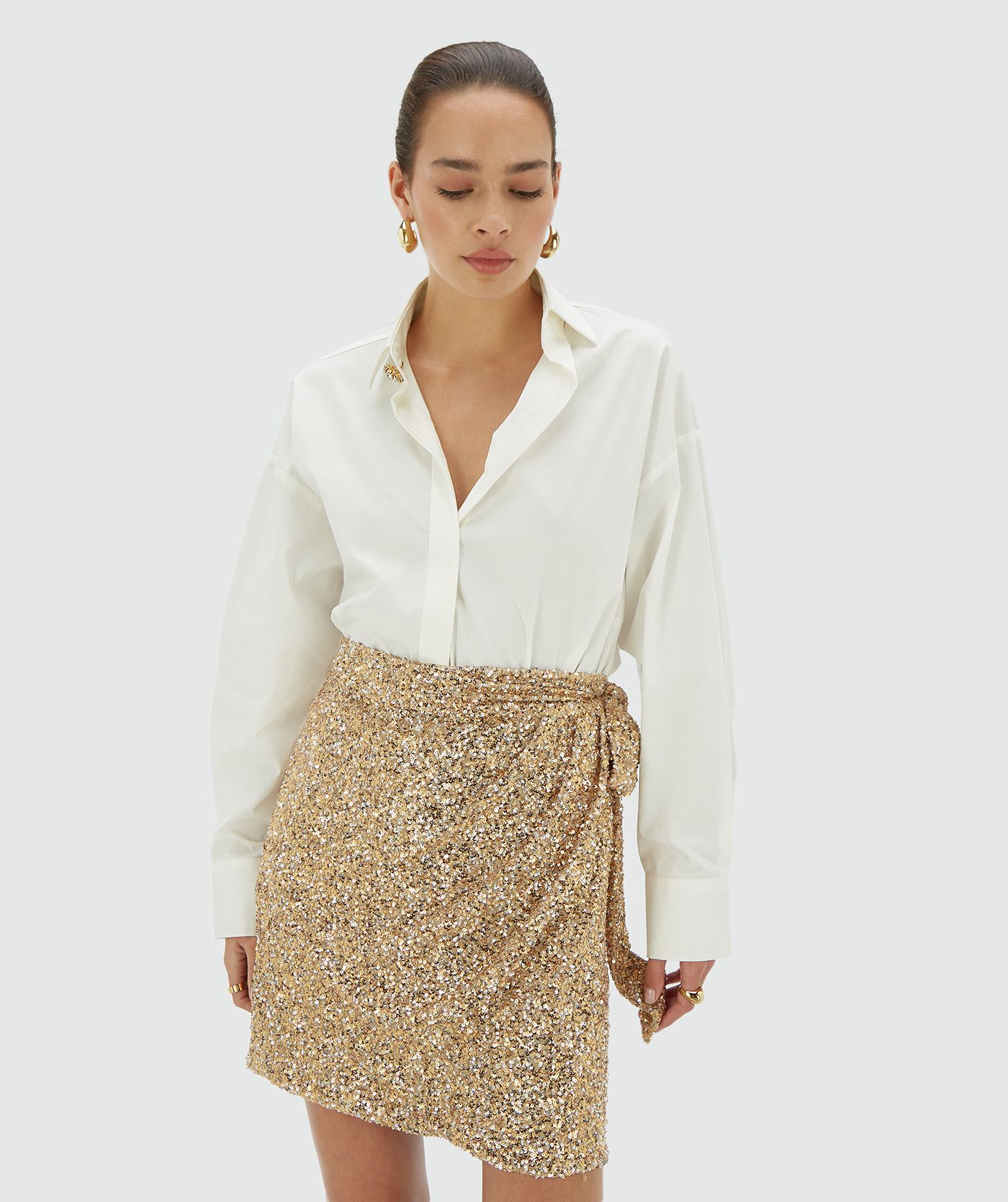 Model draagt een goud zilver pailletten rok met striksluiting - JOSH V