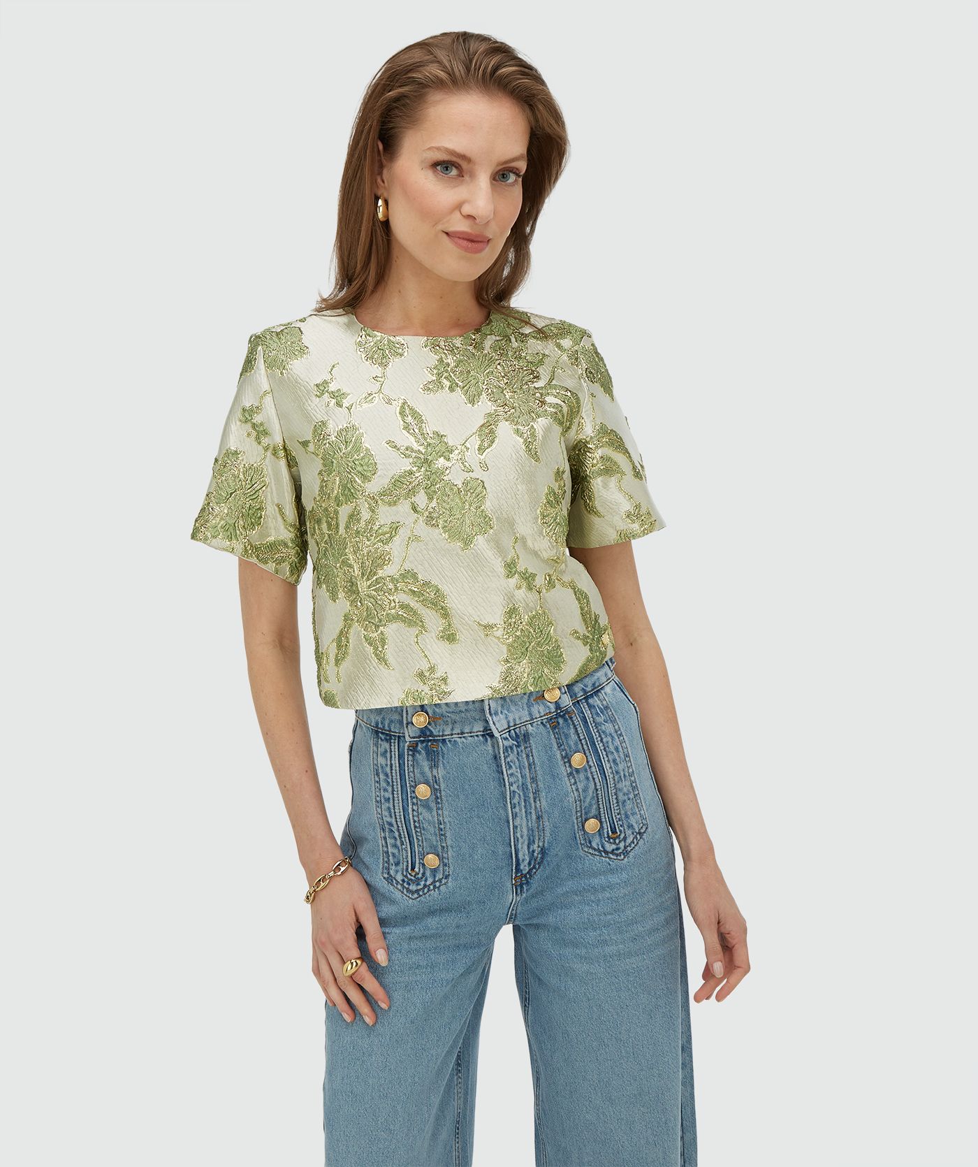 Model draagt een cropped top met metallic details in de kleur Dark Pistachio