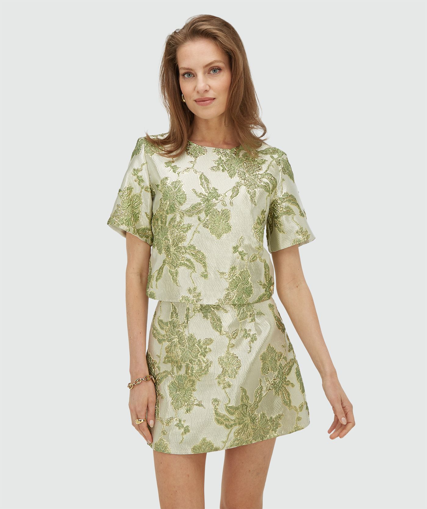 Model draagt een cropped top met metallic details in de kleur Dark Pistachio