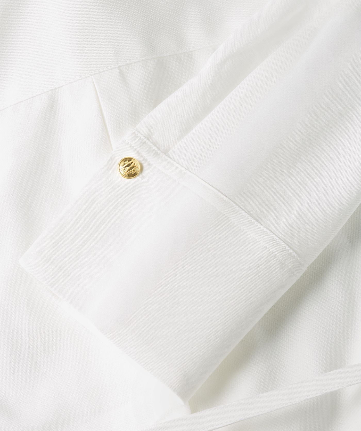Close-up van de manchetknopen van de witte blouse.