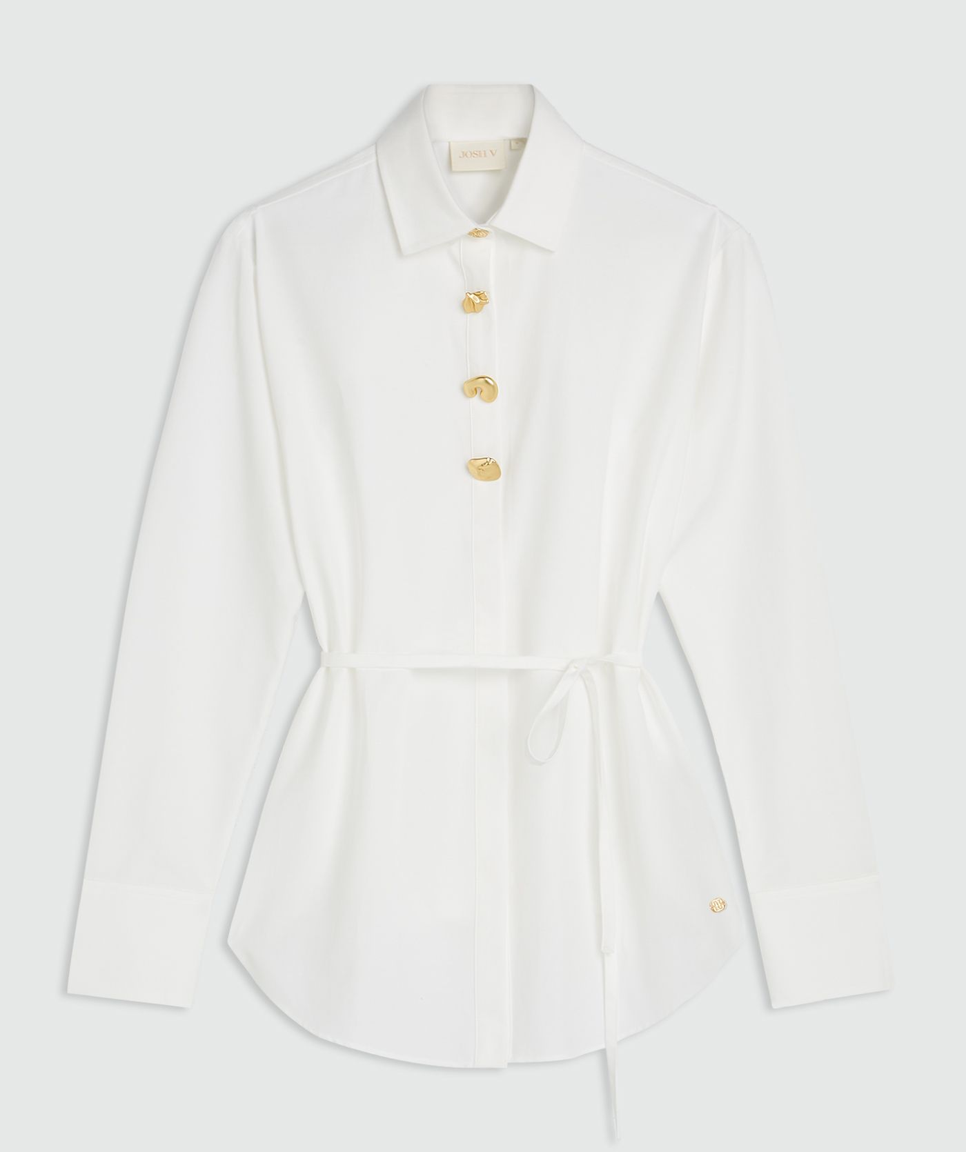 Witte blouse met aan de bovenkant vier gouden knopen en een riempje in de taille zonder model, weergegeven op een lichtgrijze achtergrond