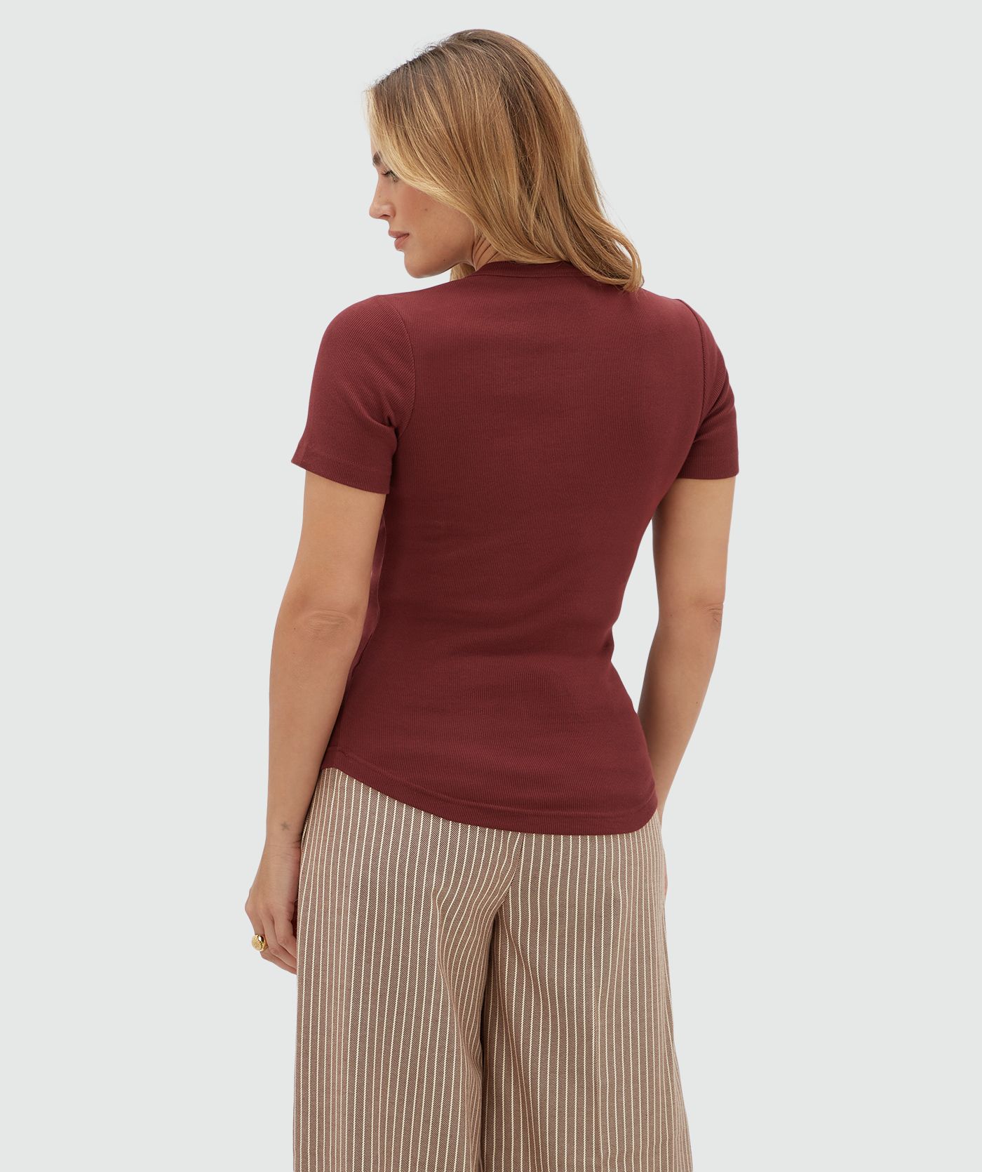 Achteraanzicht van een model in een donkerrood T-shirt.