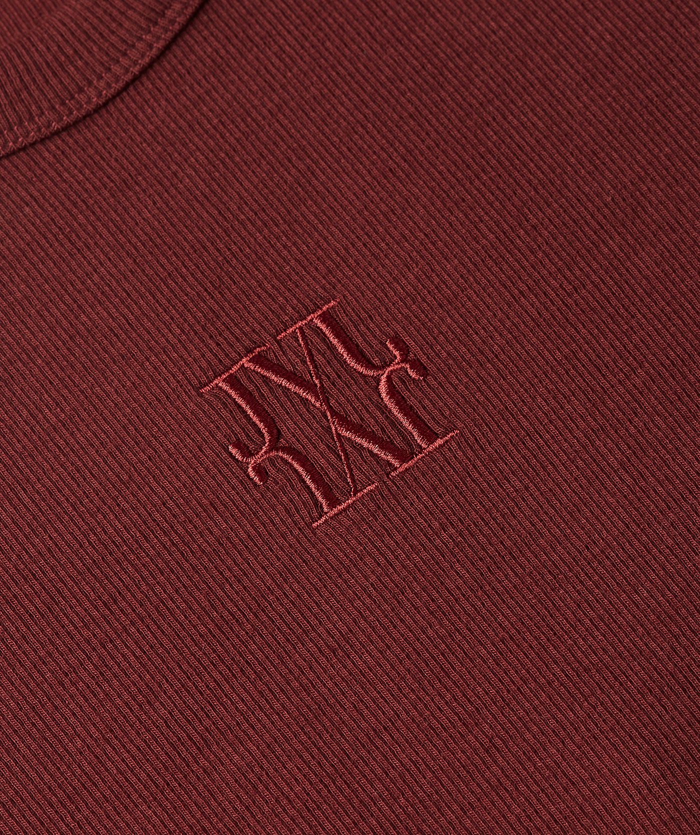 Close-up van JOSH V logo op het donkerrode T-shirt.
