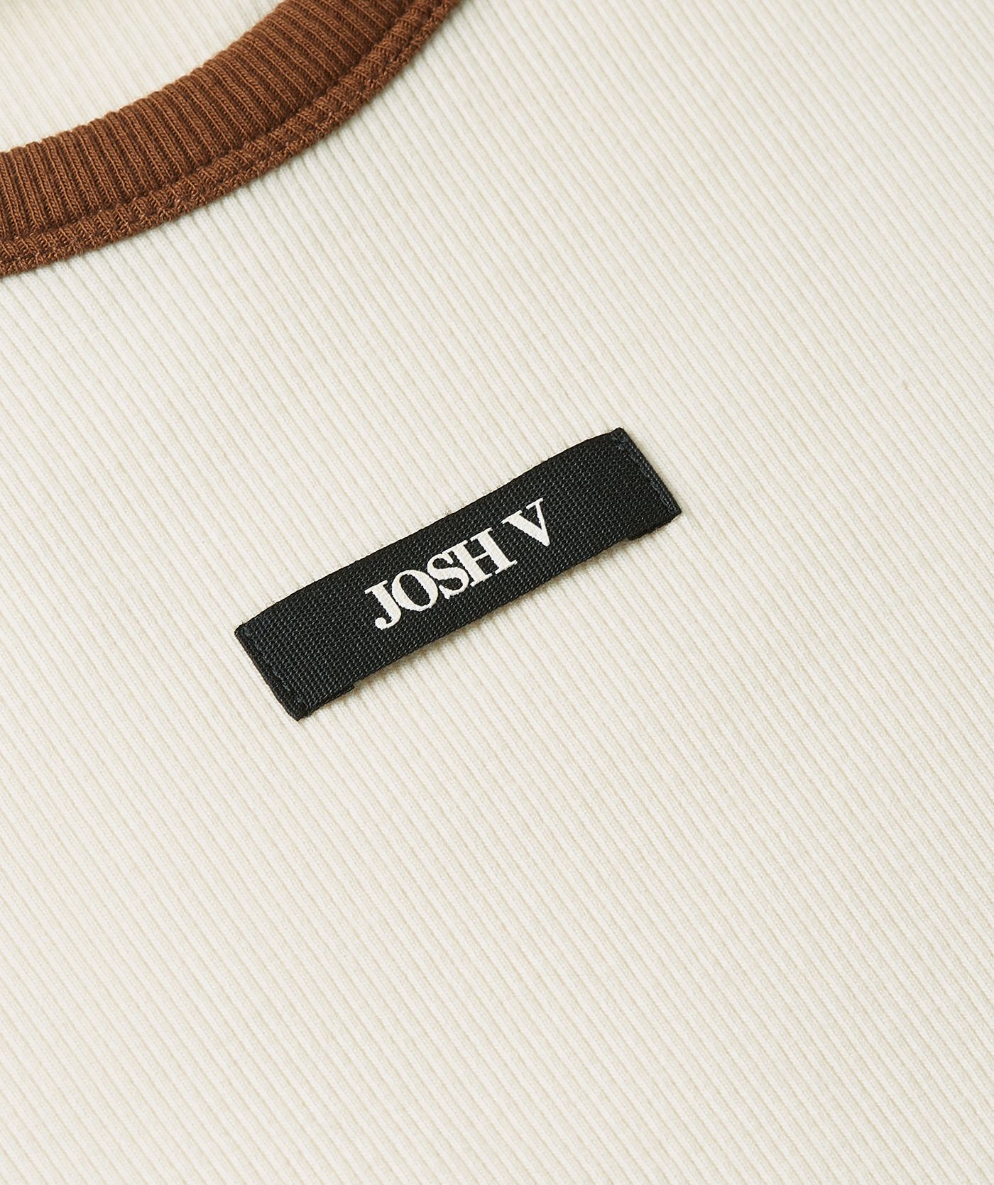 Close-up van zwart JOSH V label wat op de voorkant van het witte T-shirt zit.