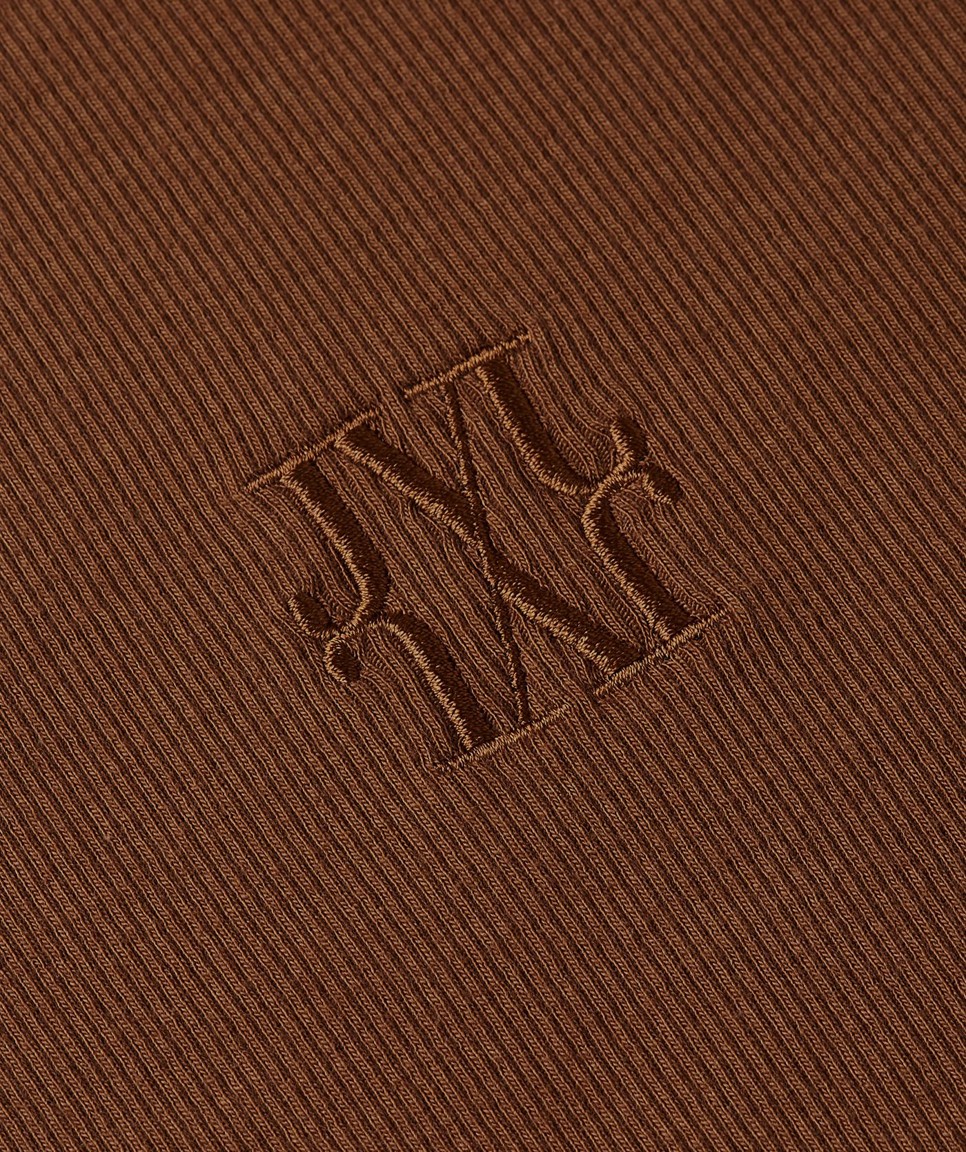Close-up van het JOSH V logo op het donkerbruine T-shirt.