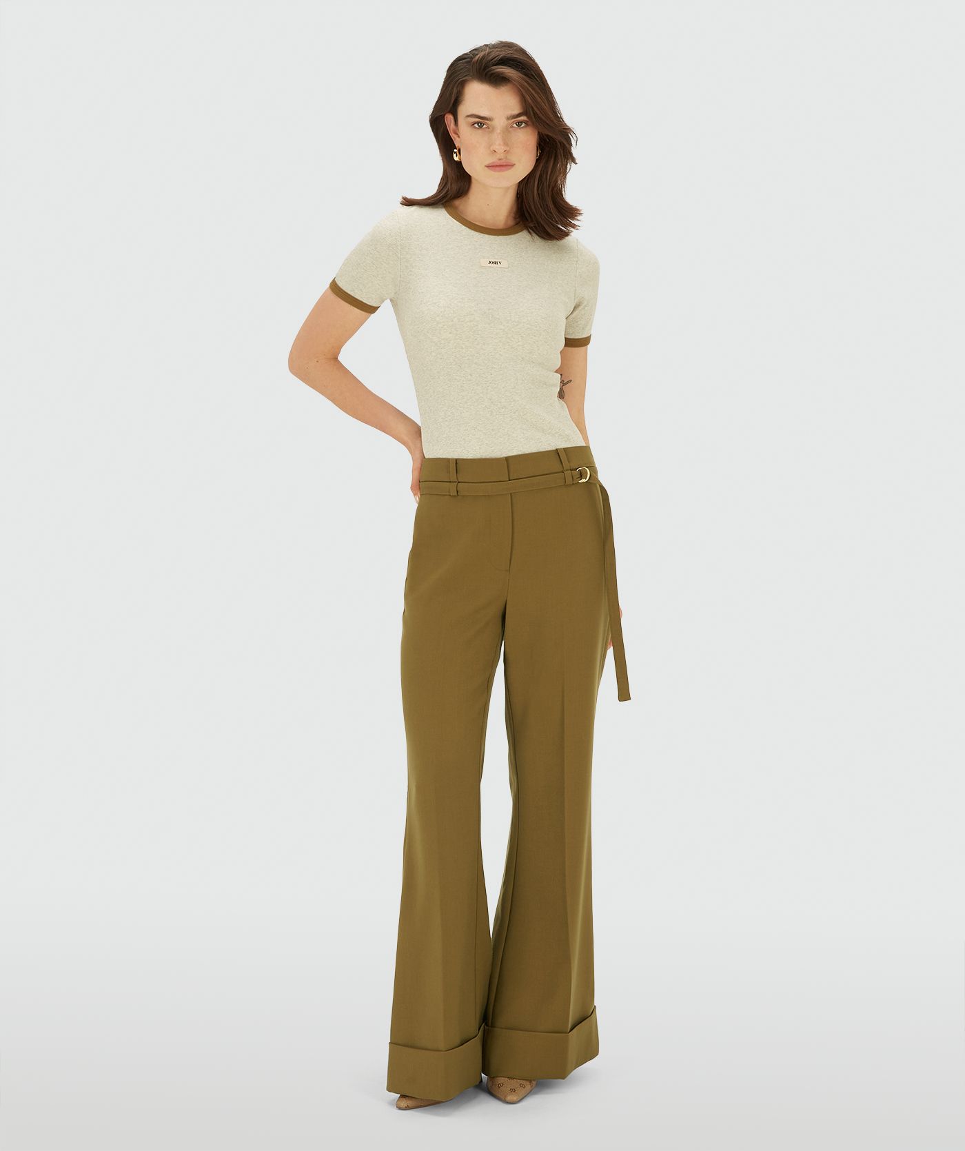 Model draagt een Ecru Melange ribgebreid T-shirt met contrasterende boord bij de hals en mouwen en een subtiel JOSH V-label op de borst