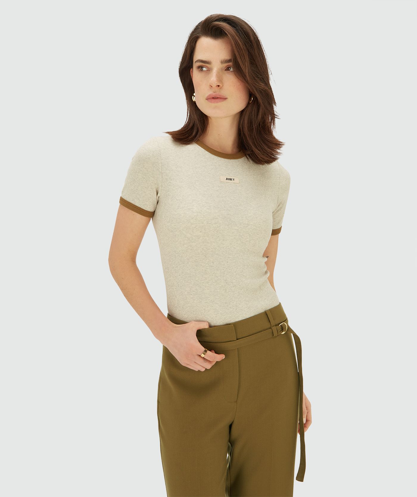 Model draagt een Ecru Melange ribgebreid T-shirt met contrasterende boord bij de hals en mouwen en een subtiel JOSH V-label op de borst