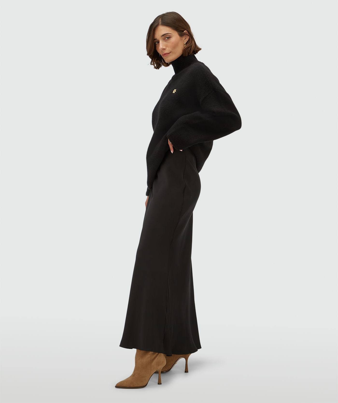 Zijaanzicht van een model in een high waisted maxi rok in een satijn look 