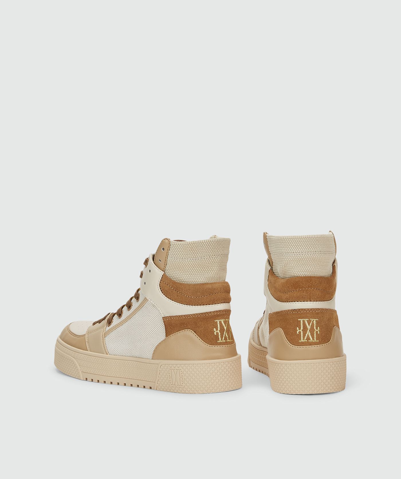 Achetrkant van hoge sneakers met camel en gebroken wit zonder model, weergegeven op een lichtgrijze achtergrond.
