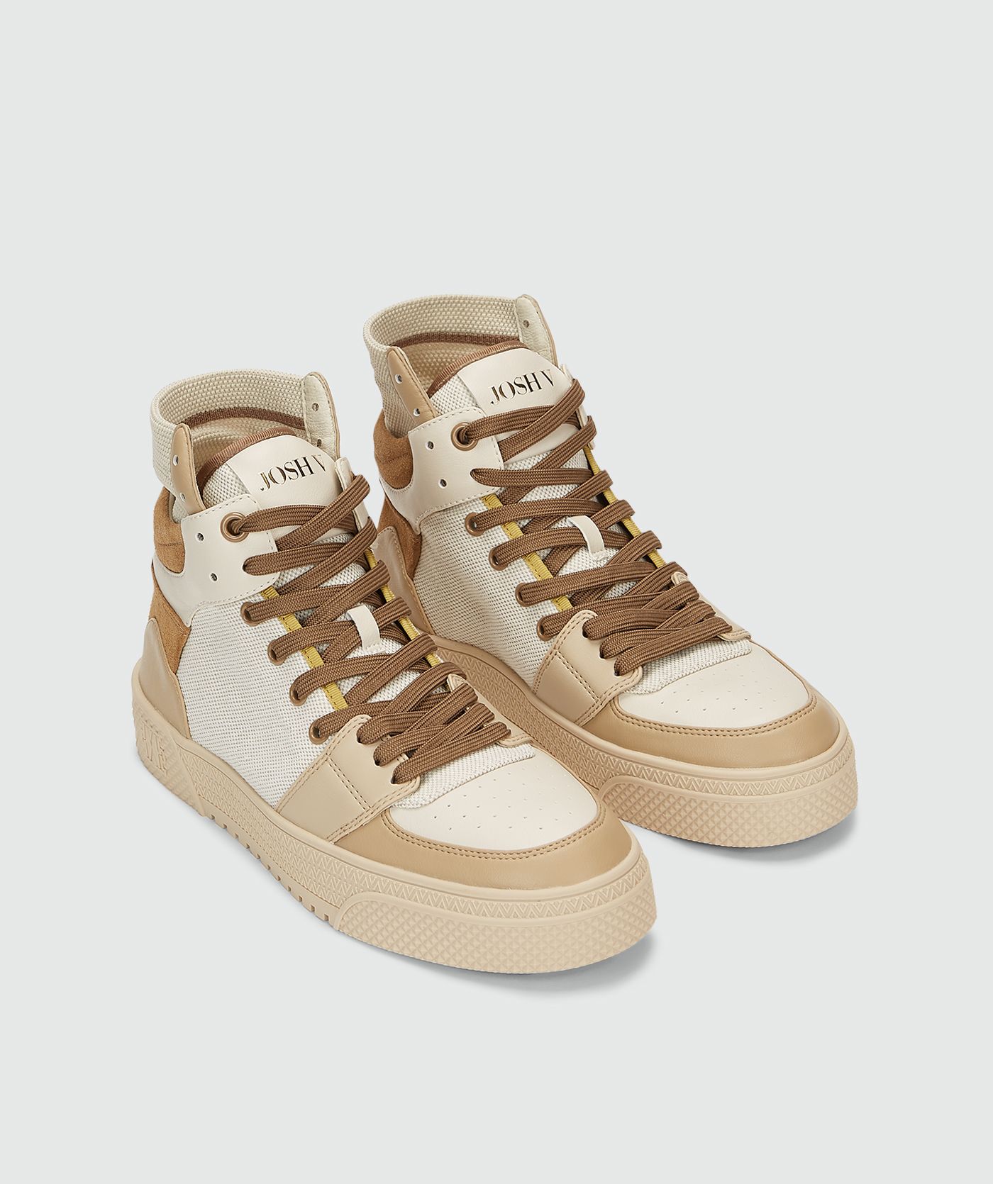 Voorkant van hoge sneakers met camel en gebroken wit zonder model, weergegeven op een lichtgrijze achtergrond.
