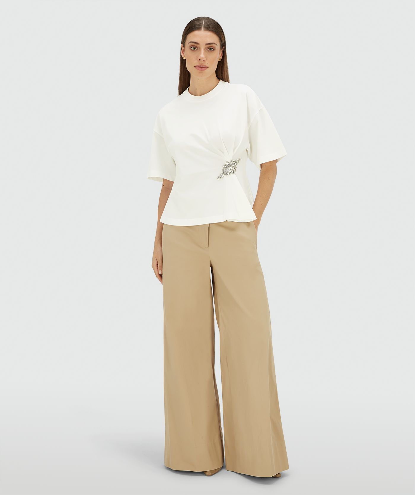 Model draagt een wit regular fit T-shirt met strass aan de voorzijde