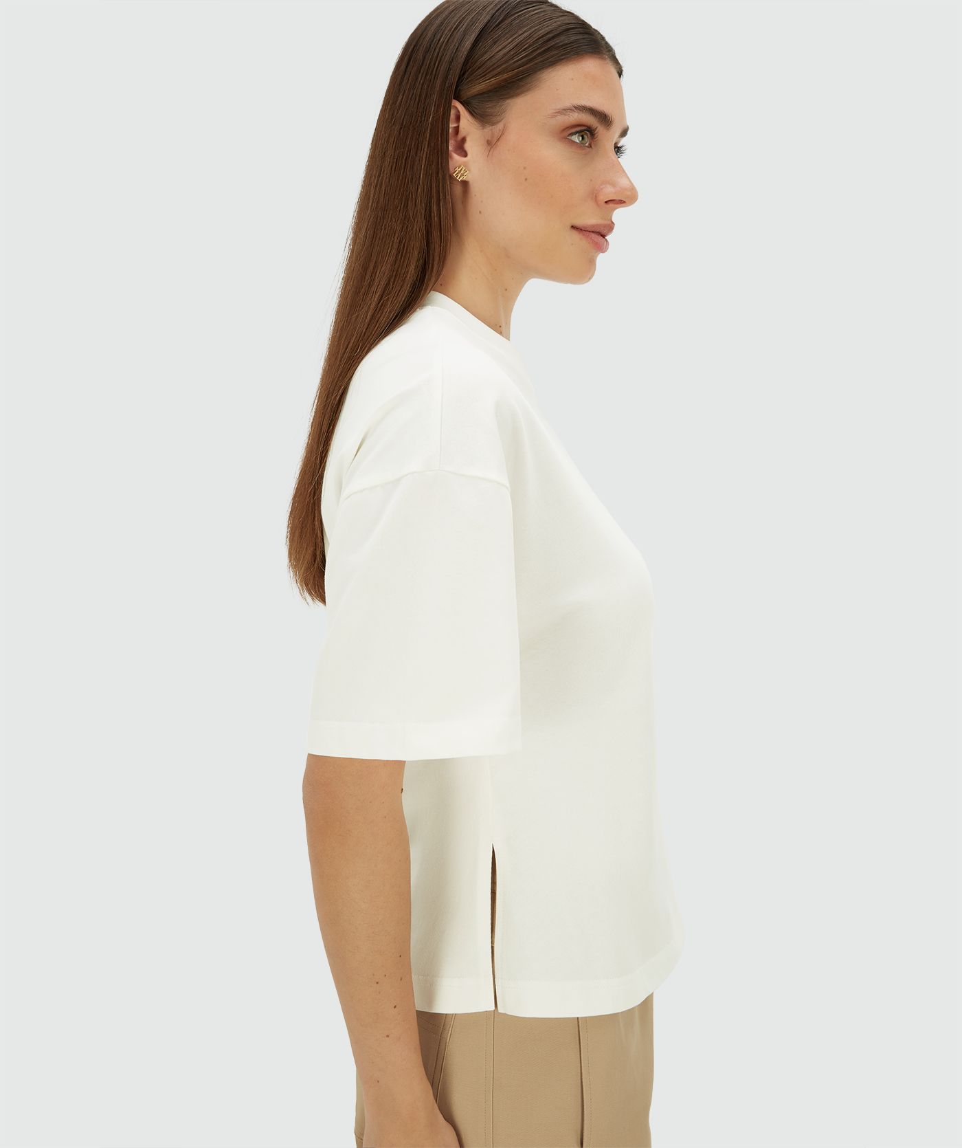 Zijaanzicht waar een model een wit regular fit T-shirt met strass aan de voorzijde draagt
