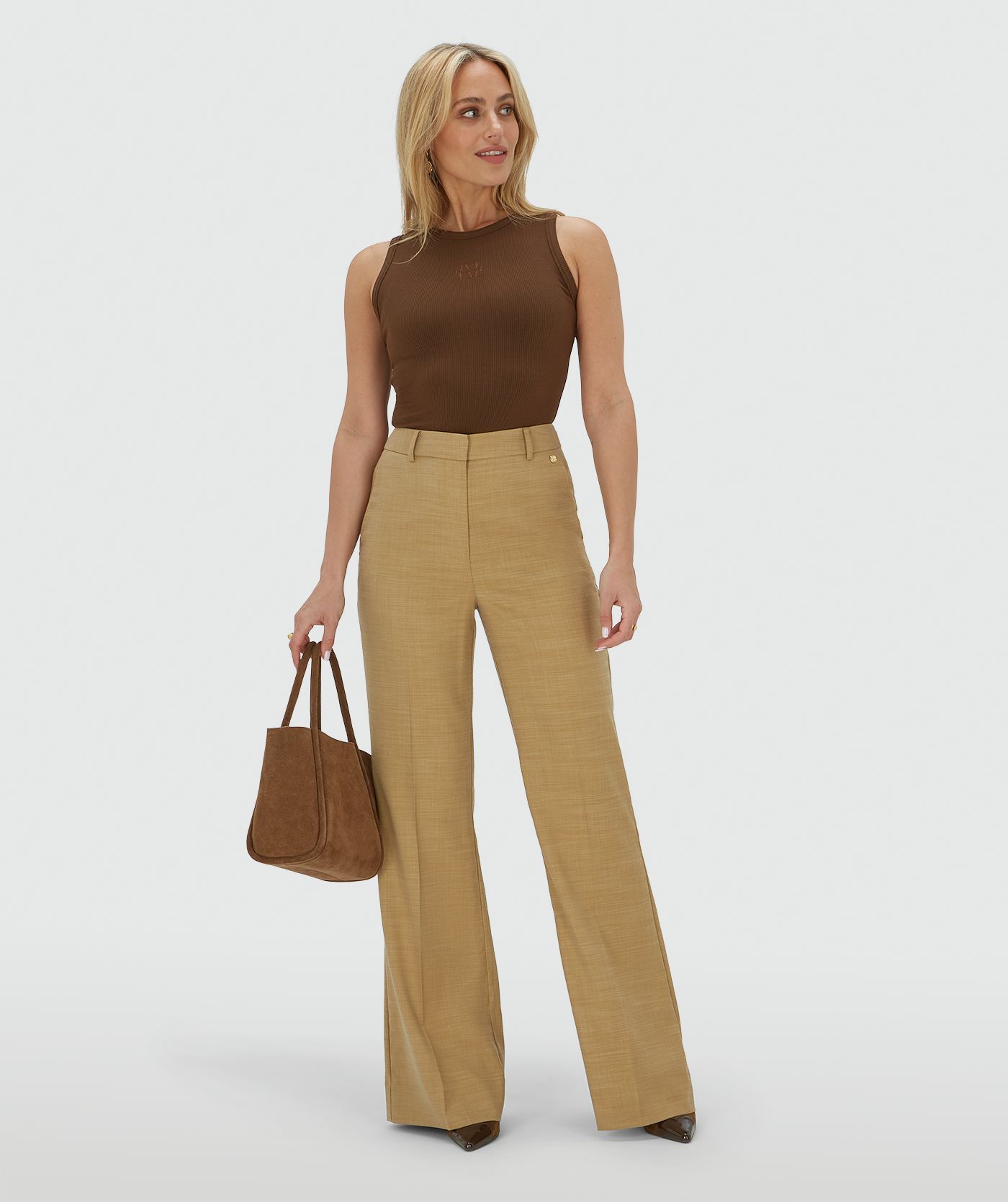Model draagt een high rise fitted pantalon in de kleur Light Camel