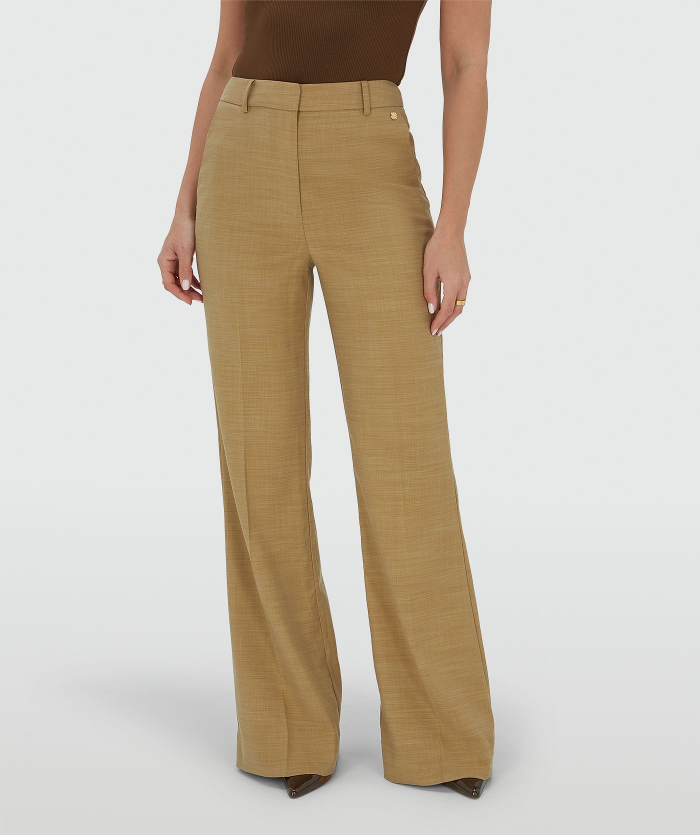 Ingezoomd beeld van een model in een high rise fitted pantalon in de kleur Light Camel