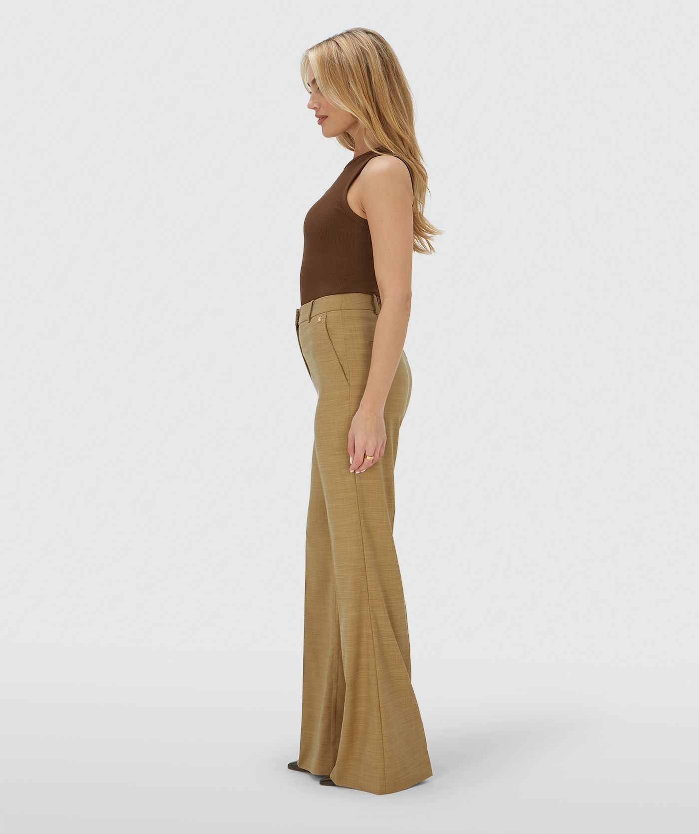 Zijaanzicht van een model in een high rise fitted pantalon in de kleur Light Camel