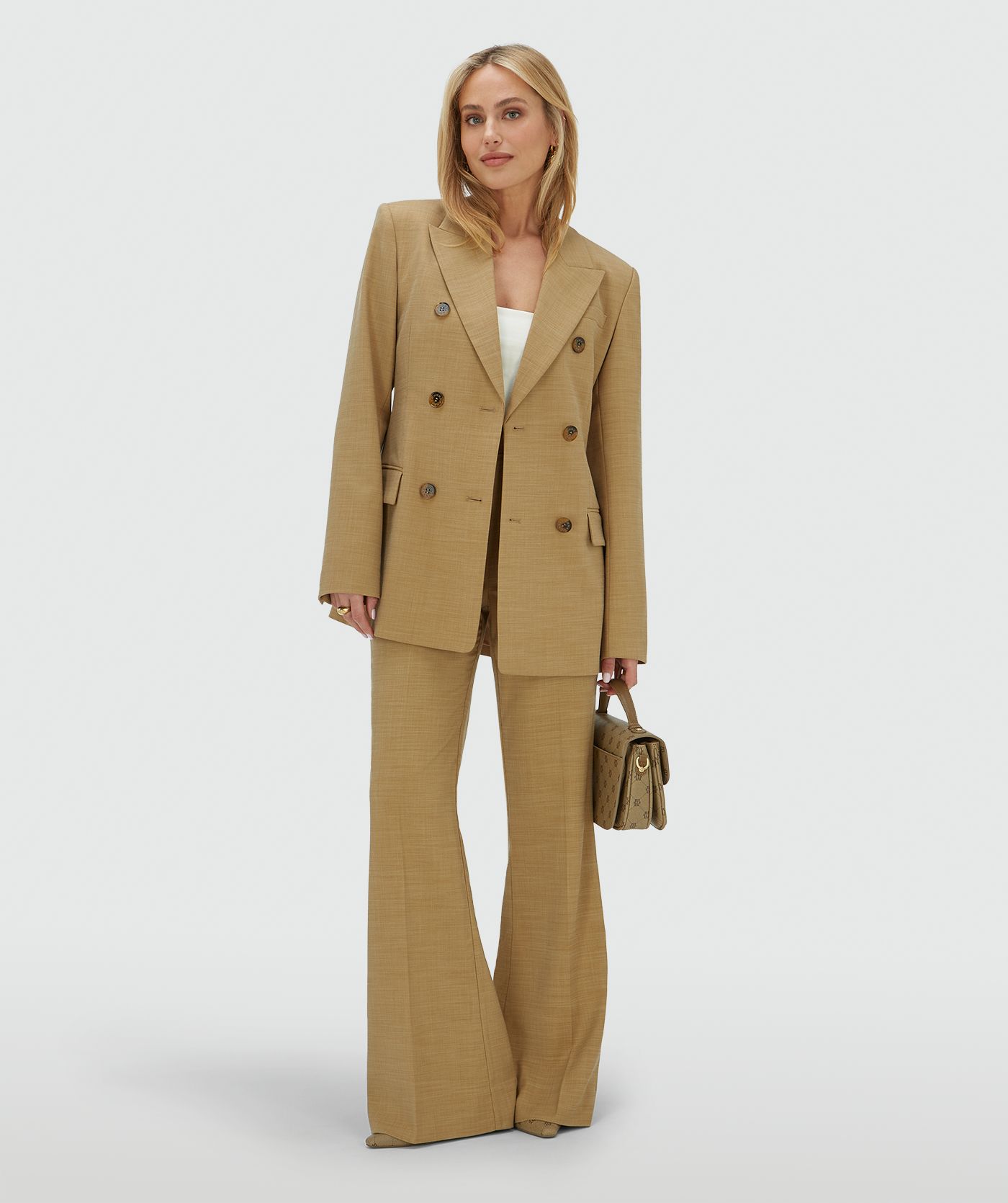 Model draagt een high rise fitted pantalon in de kleur Light Camel