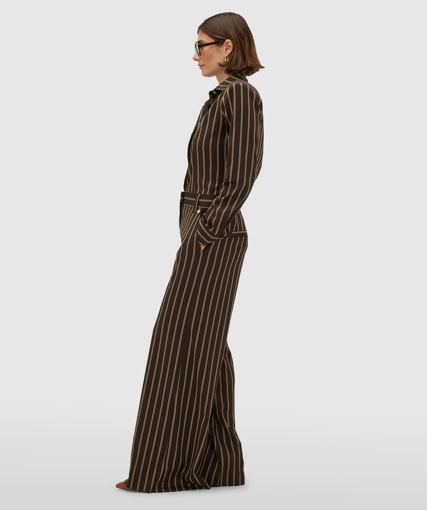 Zijaanzicht van een model in een mid rise wide leg pantalon met strepen