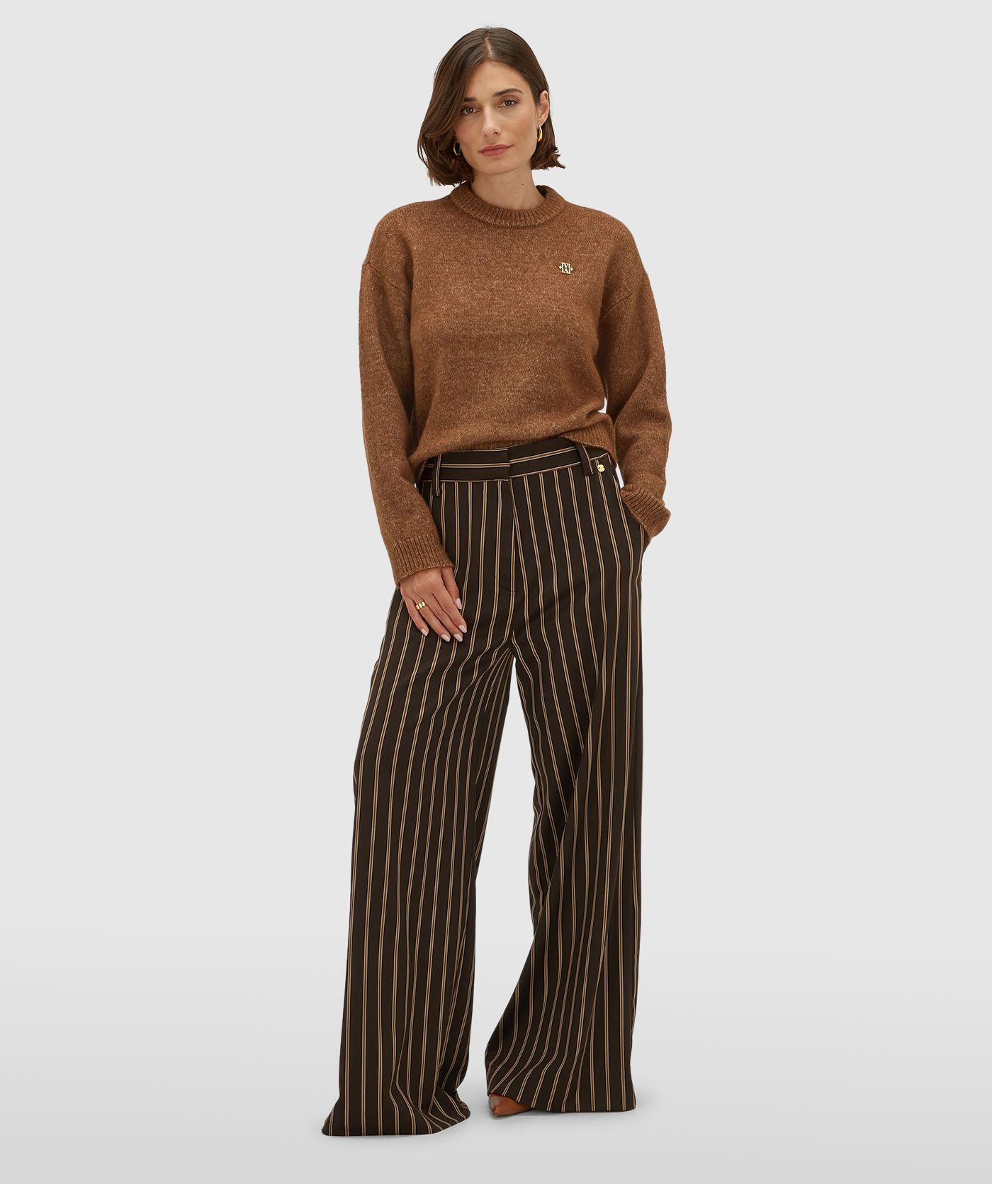 Model draagt een mid rise wide leg pantalon met strepen